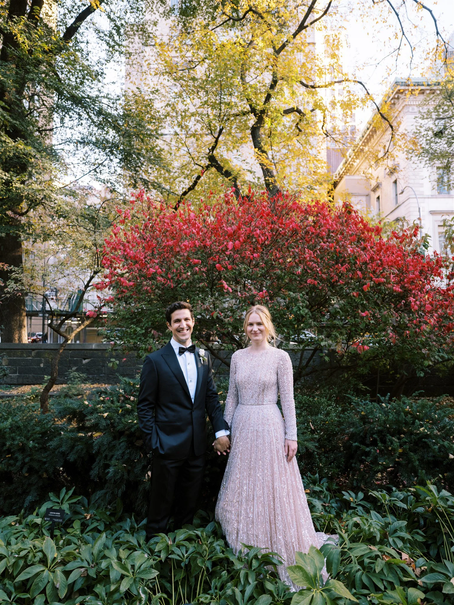 Bride and groom hold hands in garden in central park new york.  michelle rago destinations wedding