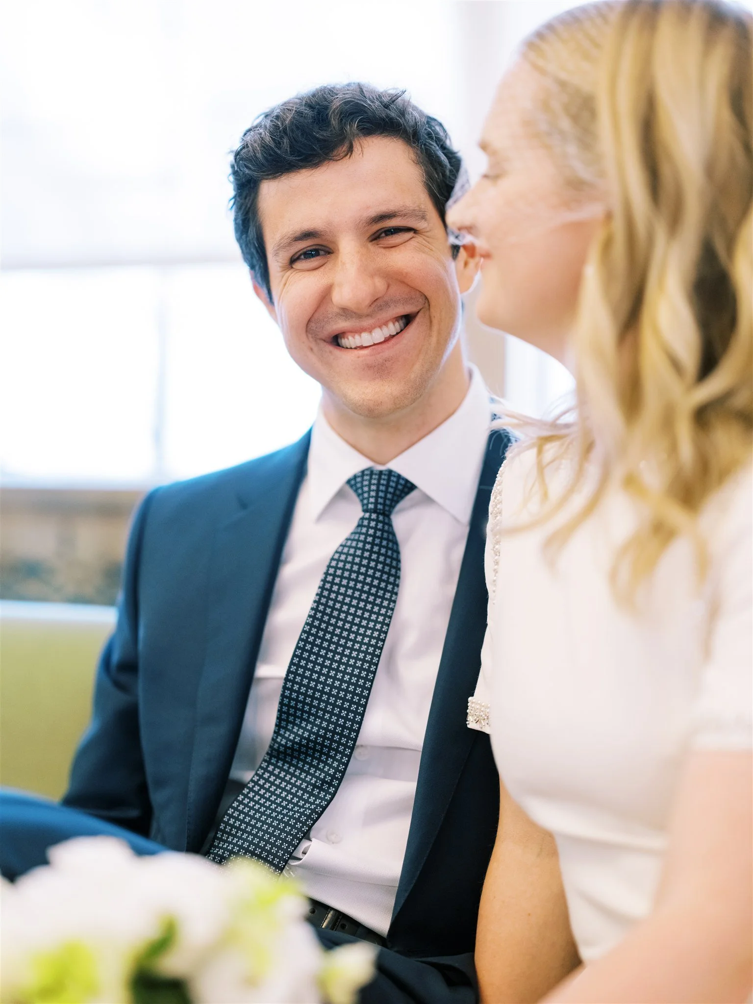 Close-up of the groom smiling while seated beside his bride. new york city courthouse elopement photography.