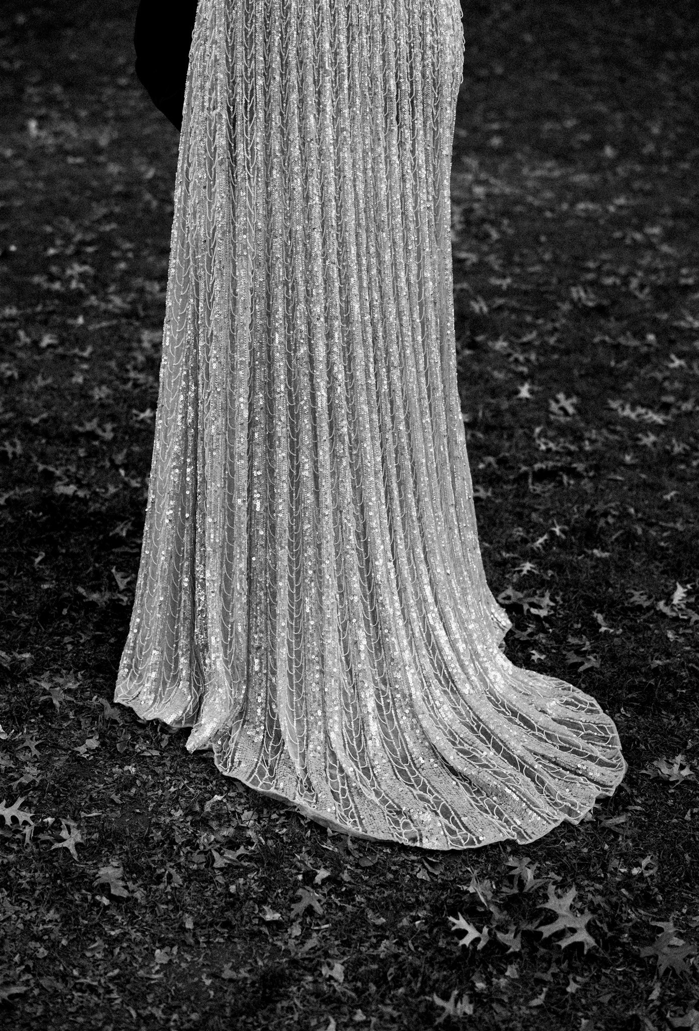 Close detail of a sequined valentino gown hem resting on the lawn. editorial nyc wedding photography.