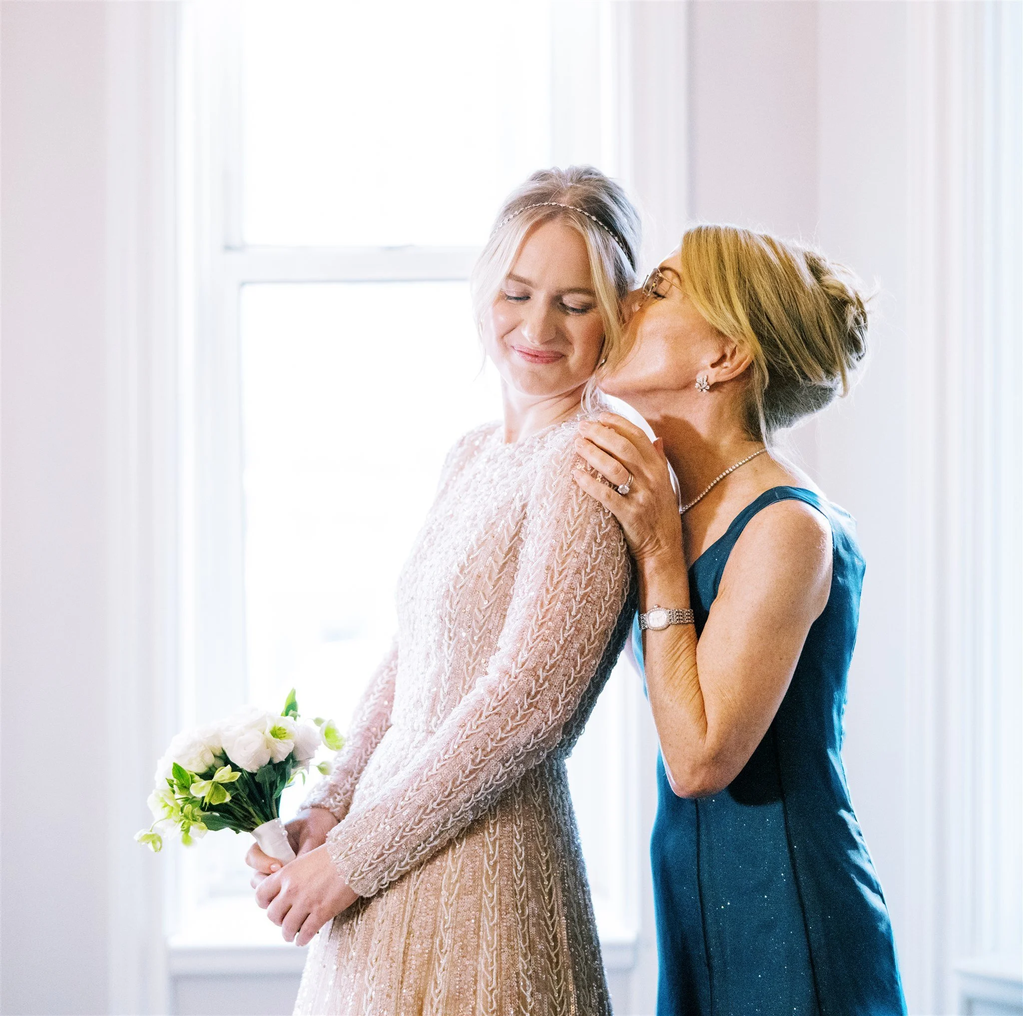 Tender moment as mother kisses the bride’s cheek before the wedding ceremony. manhattan wedding photographer new york.