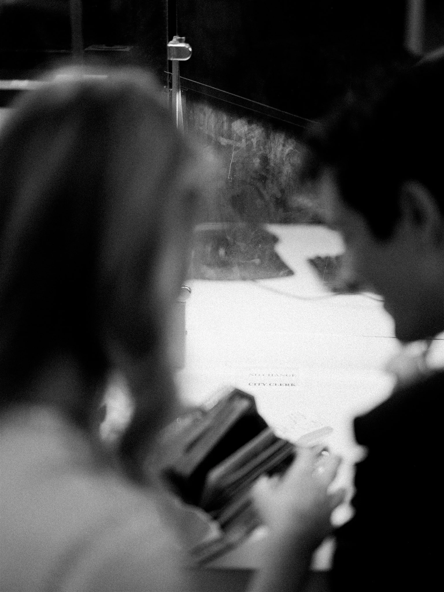Bride and groom hold hands while speaking to the clerk at the service counter. manhattan luxury wedding photographer.