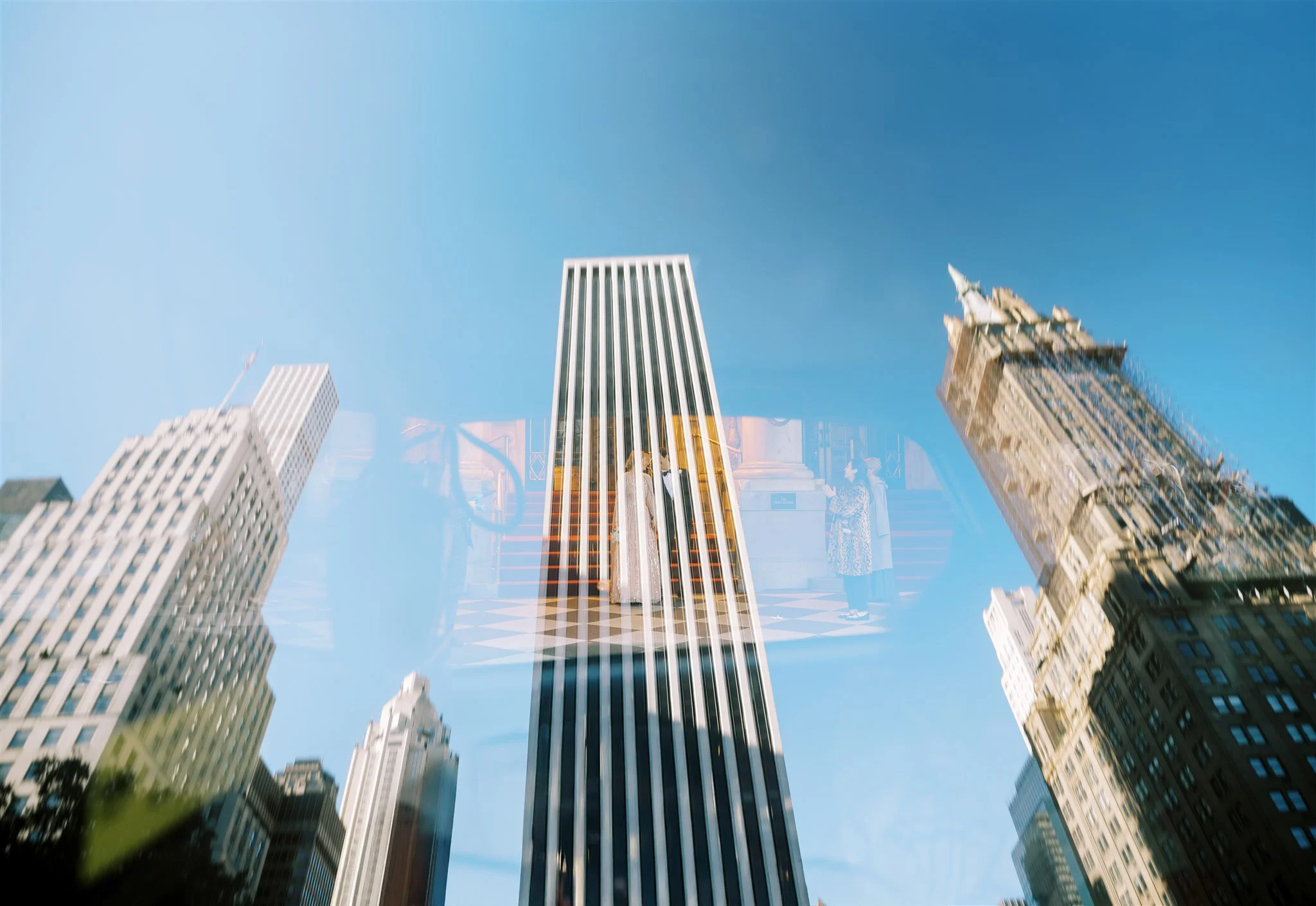 Double‑exposure of skyscrapers reflected along Fifth Avenue. manhattan wedding photographer new york.
