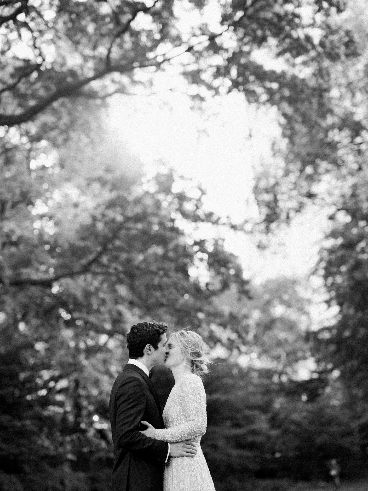 Romantic black‑and‑white kiss in Central Park. the plaza hotel nyc luxury wedding.