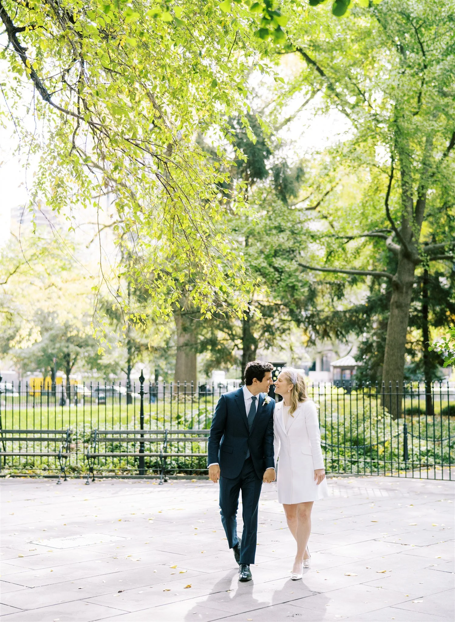 The couple strolls through a leafy park after their civil ceremony. new york city courthouse wedding photographer.