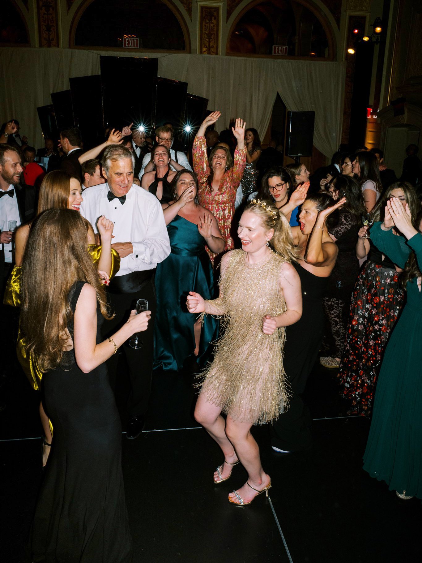 Bride dancing in a gold fringe dress surrounded by cheering guests on the dance floor. the plaza hotel nyc luxury wedding.