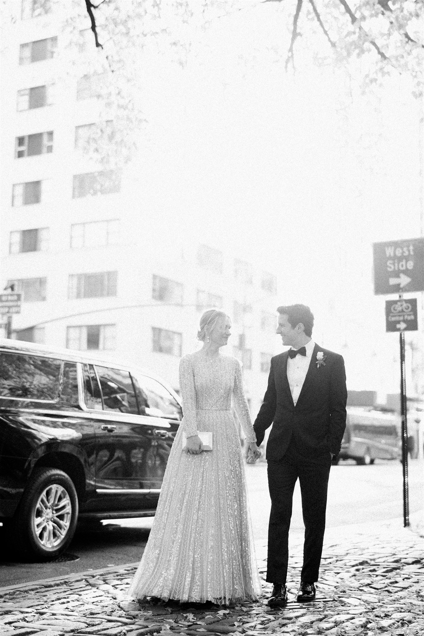 Bride and groom walk hand in hand down a cobblestone street. the plaza hotel nyc luxury wedding.