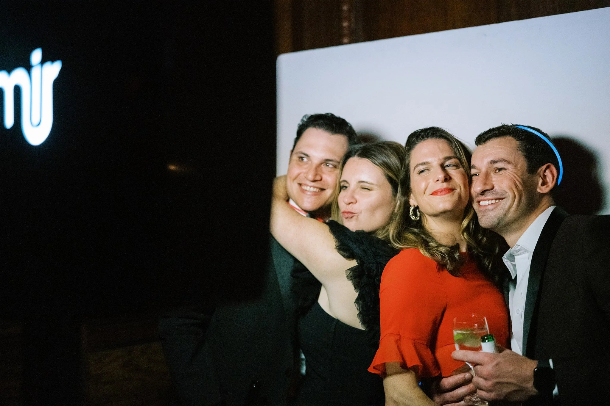 Wedding guests posing for a photo booth moment with cocktails and laughter. michelle rago destinations wedding planner nyc.