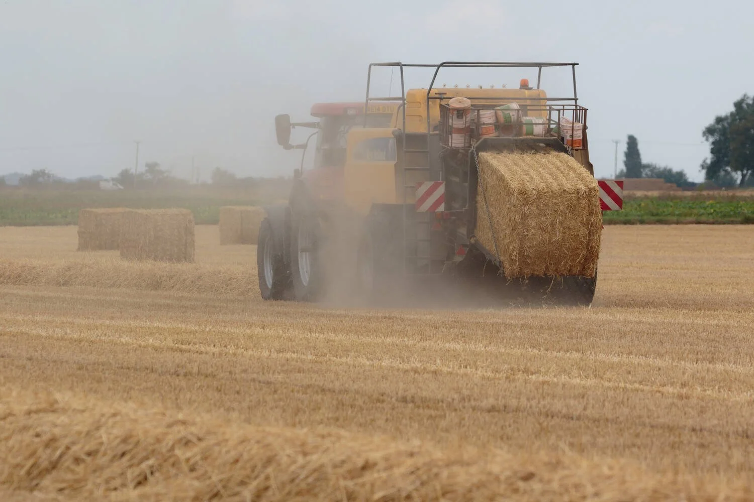 Modern case 215 tractor using a New holland straw baler.