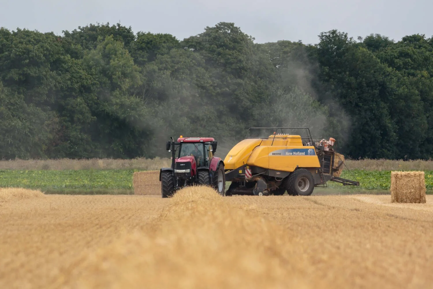 Modern case 215 tractor and a holland straw baler farming in the Fens.