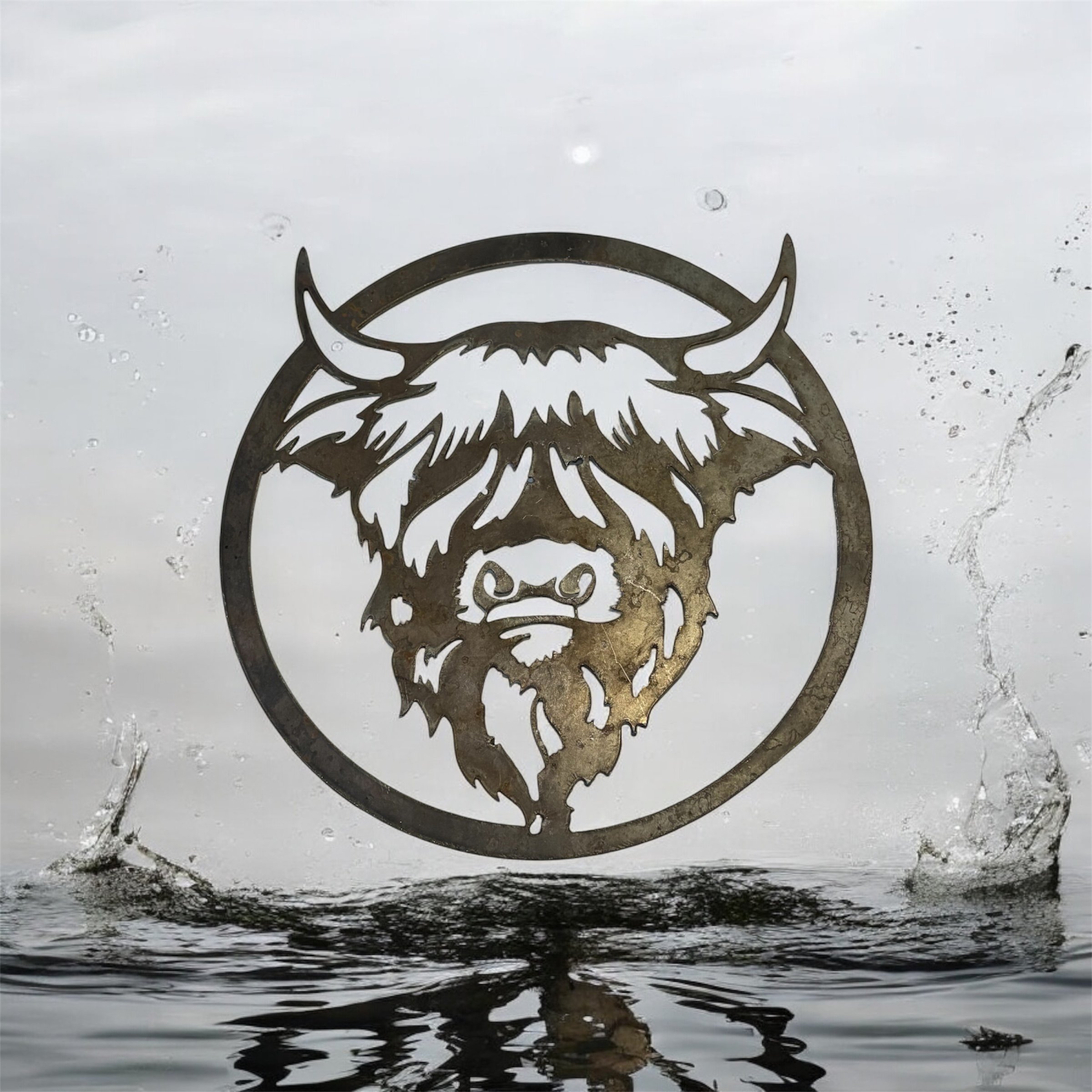 Metal cutout of a highland cow face with horns, mounted on a glass surface with water splashes around.