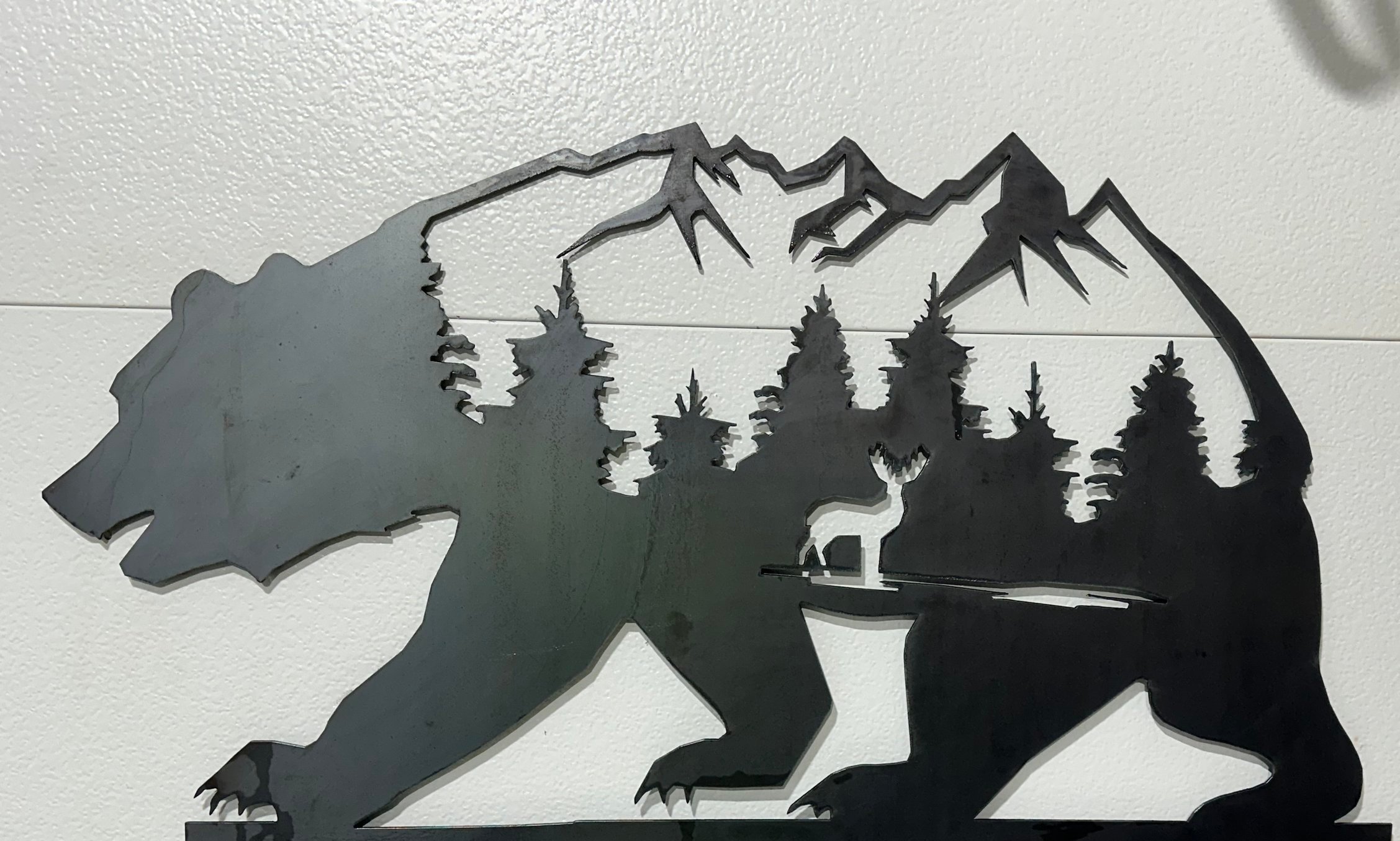 Metal wall art featuring a mountain lion with a forest and mountain scene, including a wolf silhouette and trees.