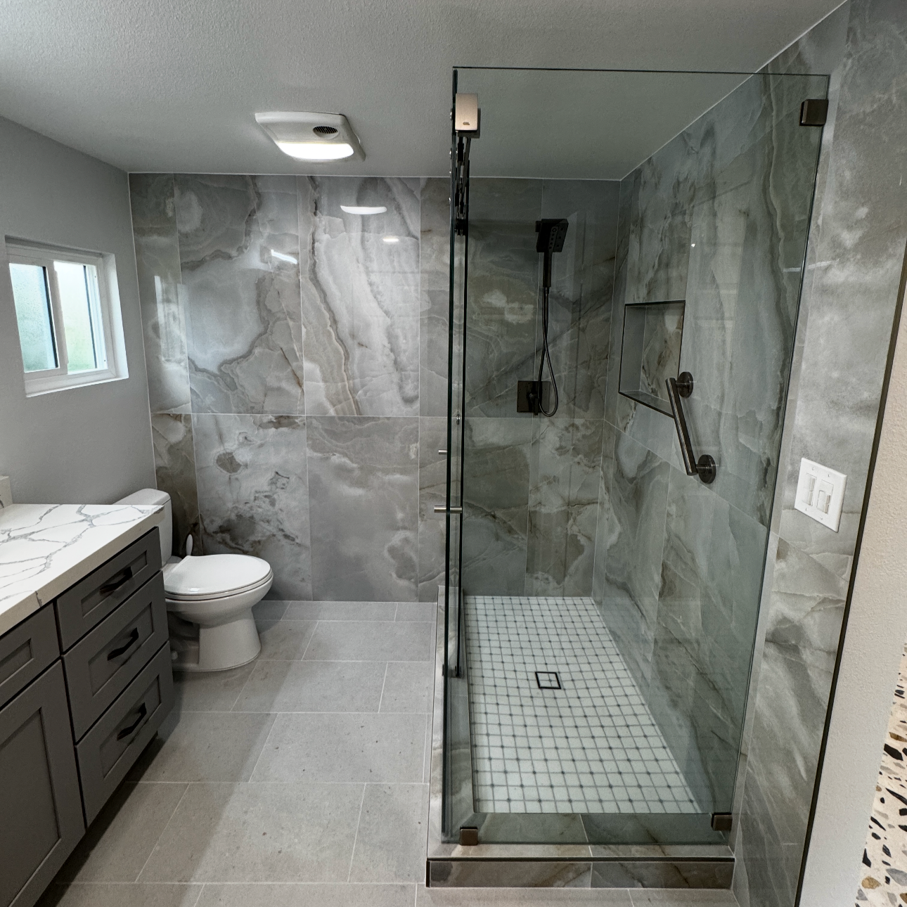 Contemporary bathroom remodel with walk in shower elegant tile work and custom vanity completed by Sam's Renovations and Home Improvments.