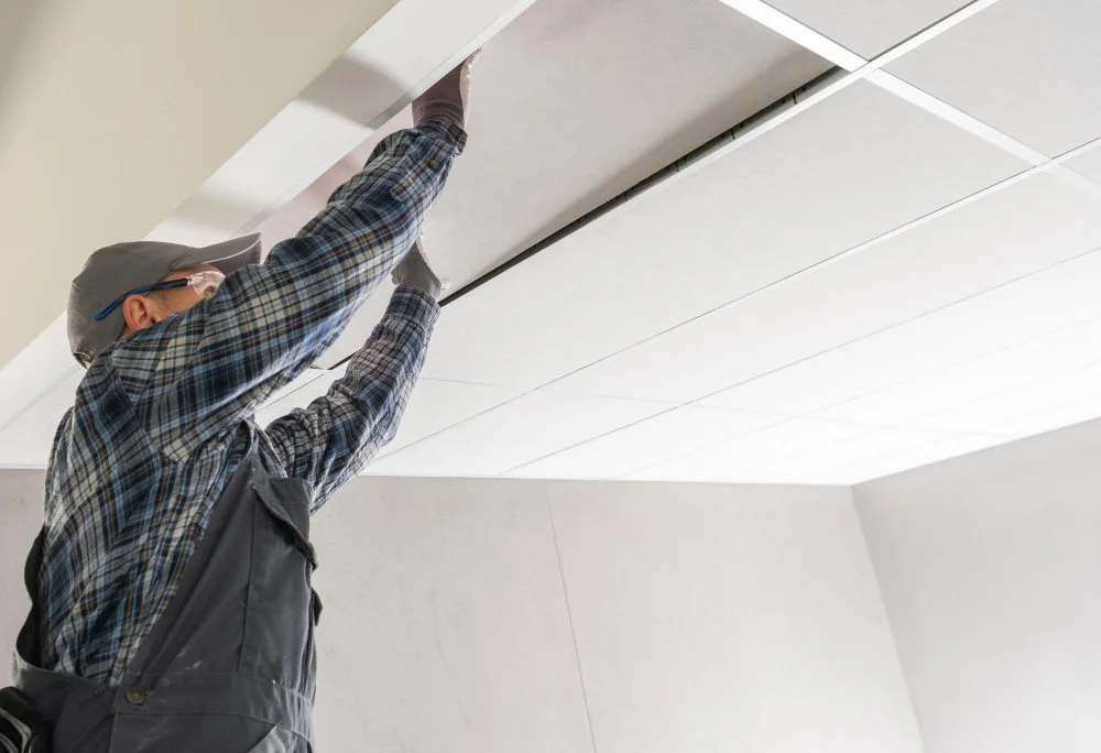 Worker installing ceiling panels during a home improvement project by Sam’s Renovations & Home Improvements.