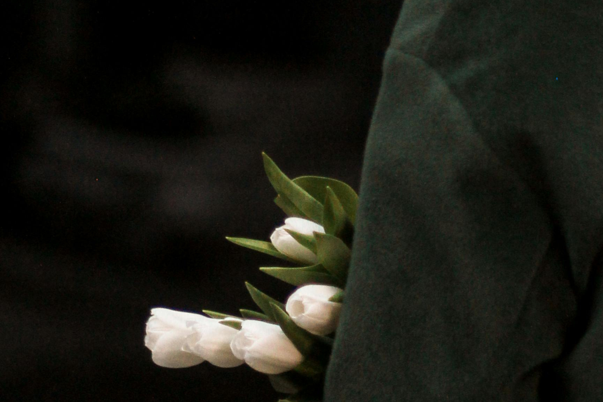 A woman holding white flowers close to her body, a quiet and reflective moment that captures the emotional layers of navigating fertility during tender seasons like Mother’s Day.