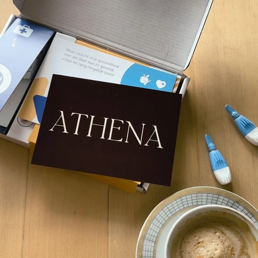 At-home fertility test kit by Athena on a wooden table with coffee, representing a quiet moment of gaining clarity on your fertility journey