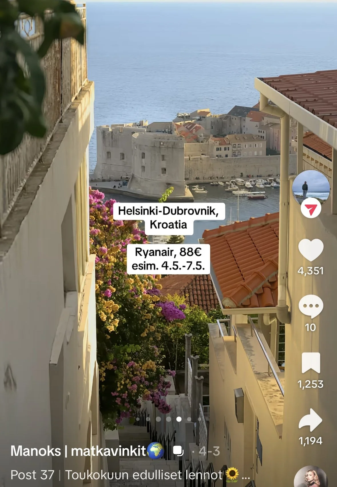Kuvassa näkyy Dubrovnikin linnoitus Kroatiassa meren äärellä, kuvassa myös punakattoisia rakennuksia ja kukkaryhmä etualalla, näkymä on katettu aukiosta merelle.