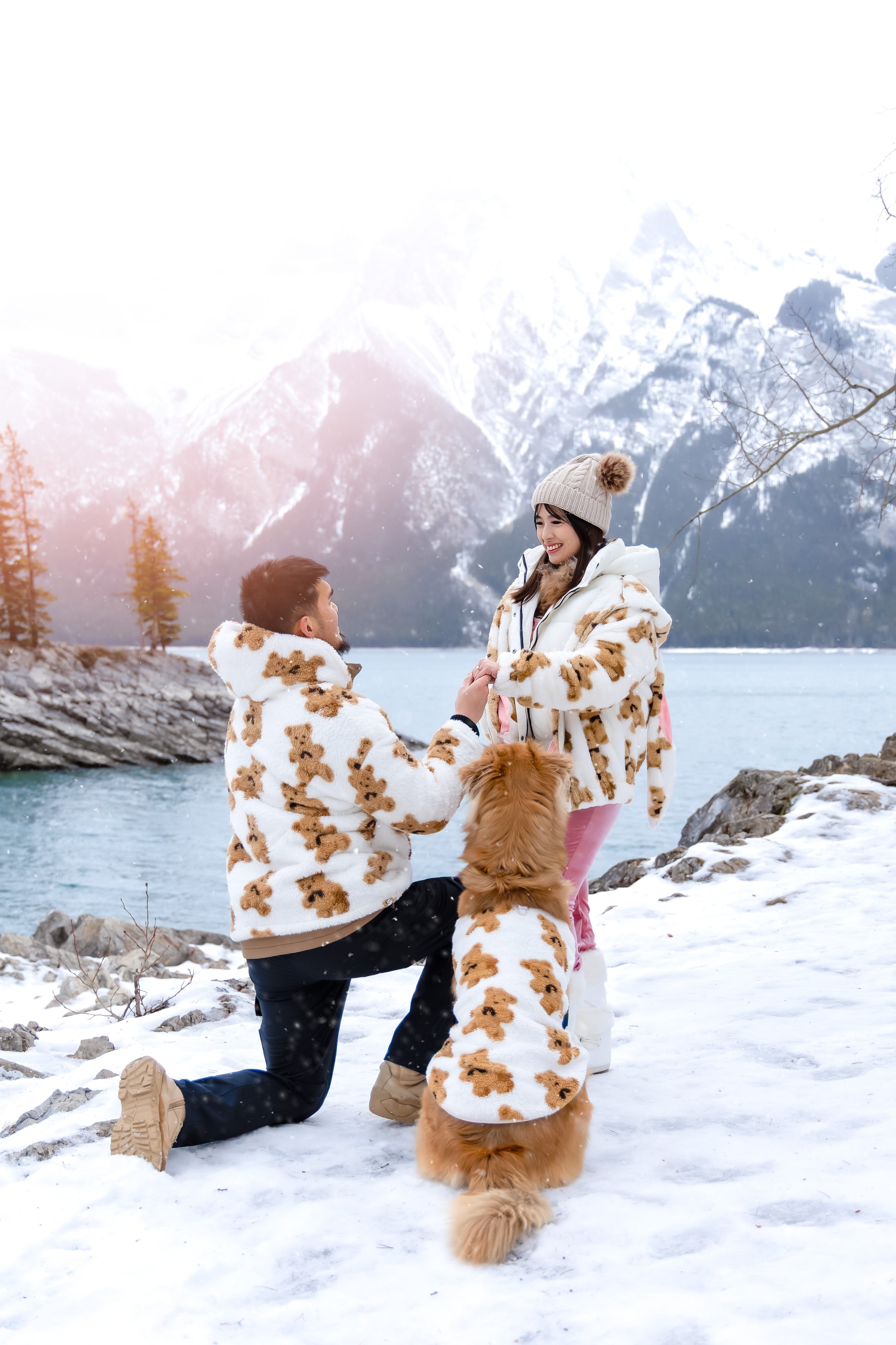 man proposing to woman at Lake Minnewanka with dog