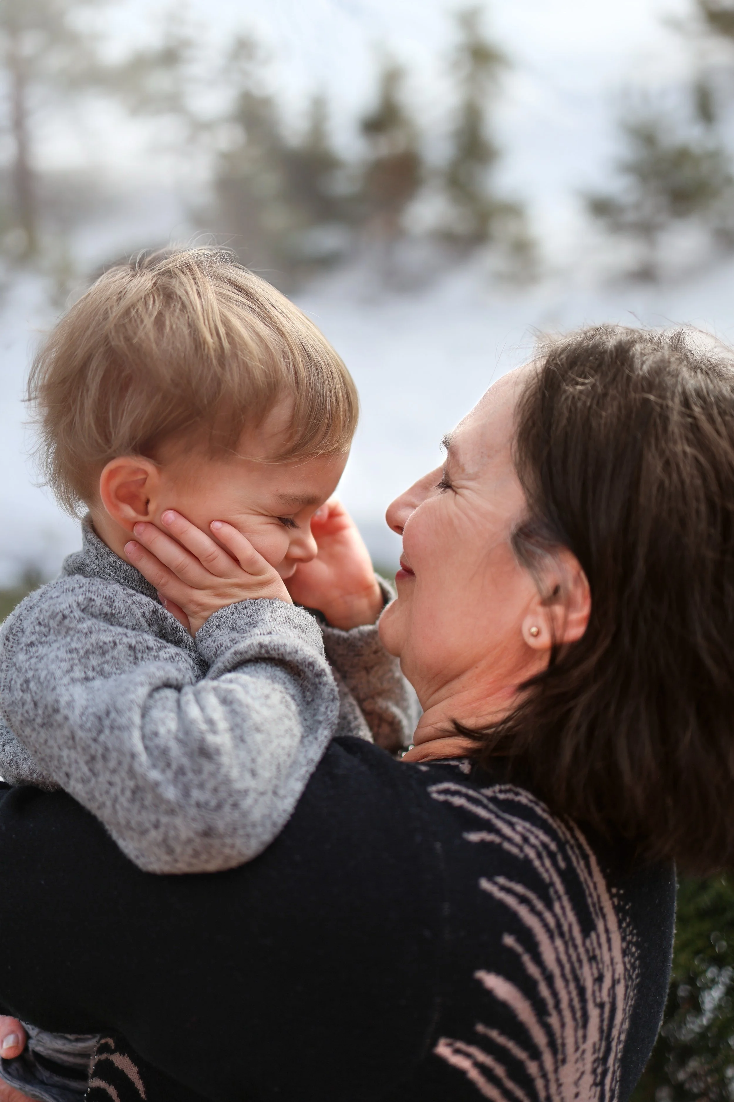 Calgary family photography, grandmother in close embrace with toddler outdoors.
