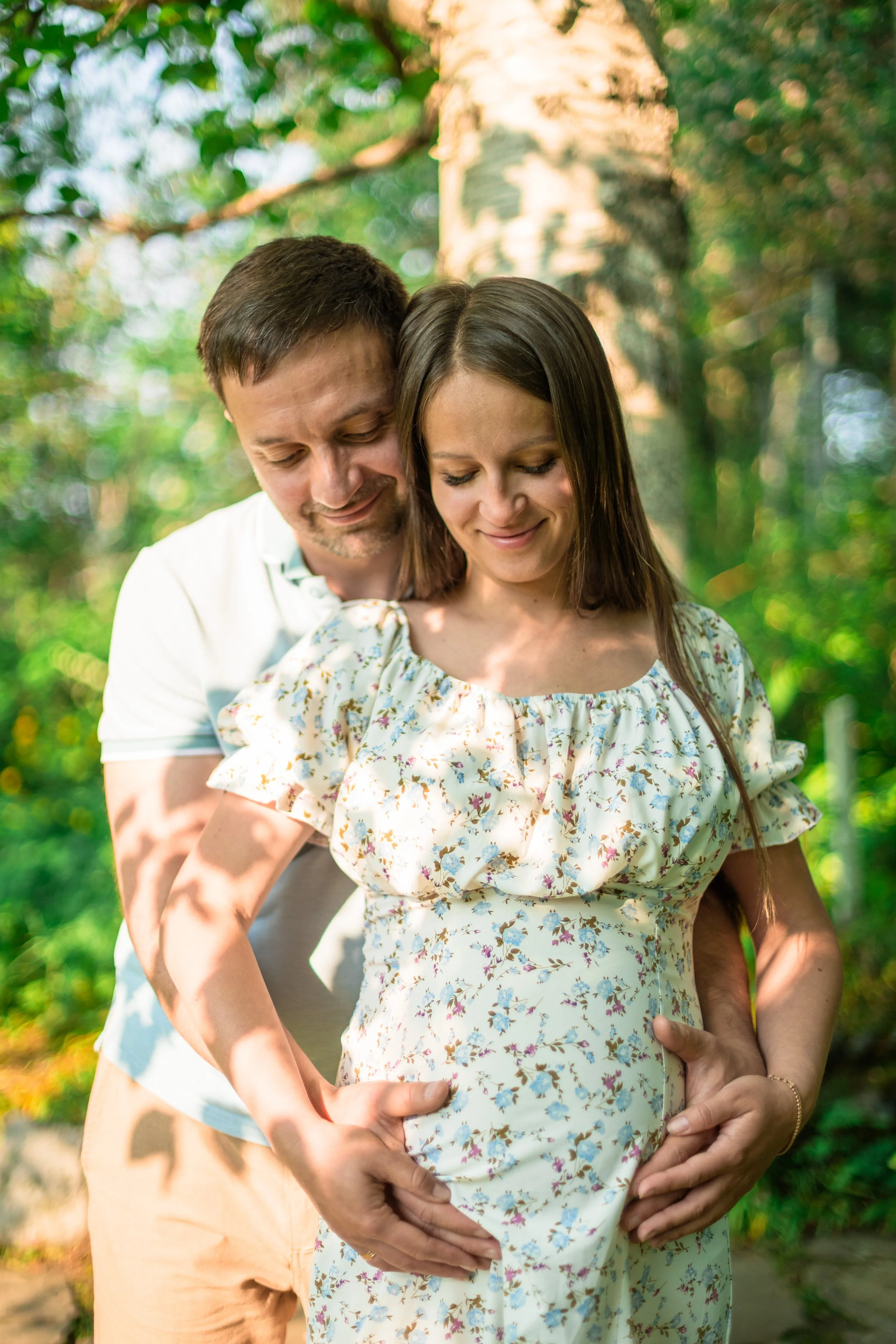 Mother and father are cradling the baby bump during a maternity photo session in Reader Rock Garden Calgary.