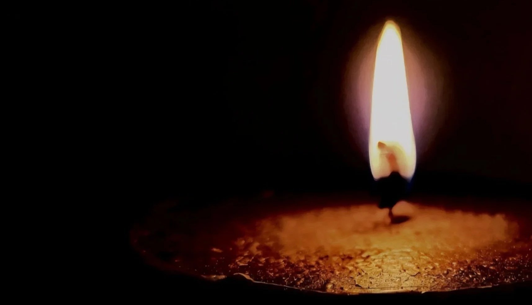 Burning candle with black background