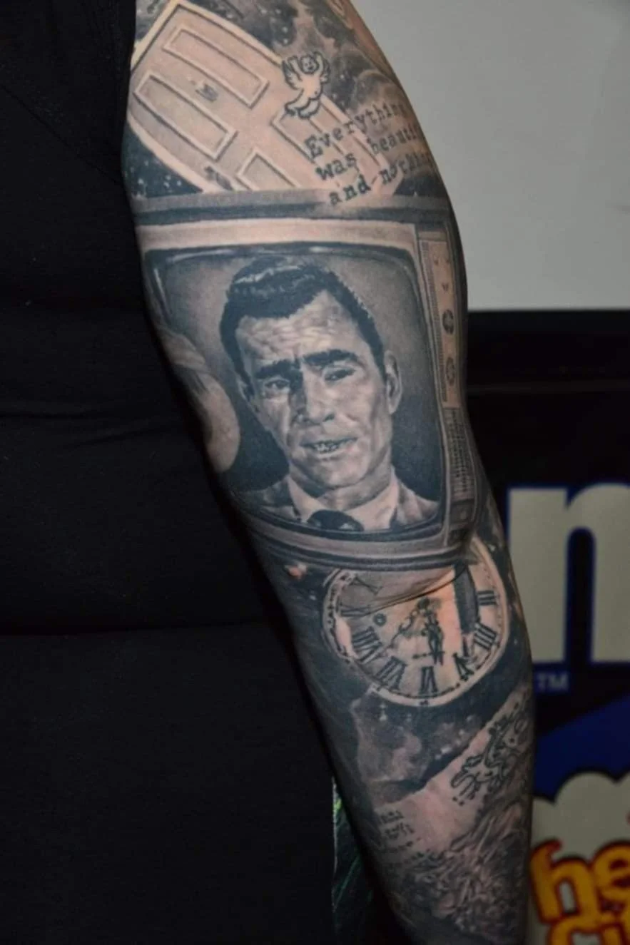Tattoo sleeve with a vintage television screen displaying a man’s face, a pocket watch showing the time, and various other images.