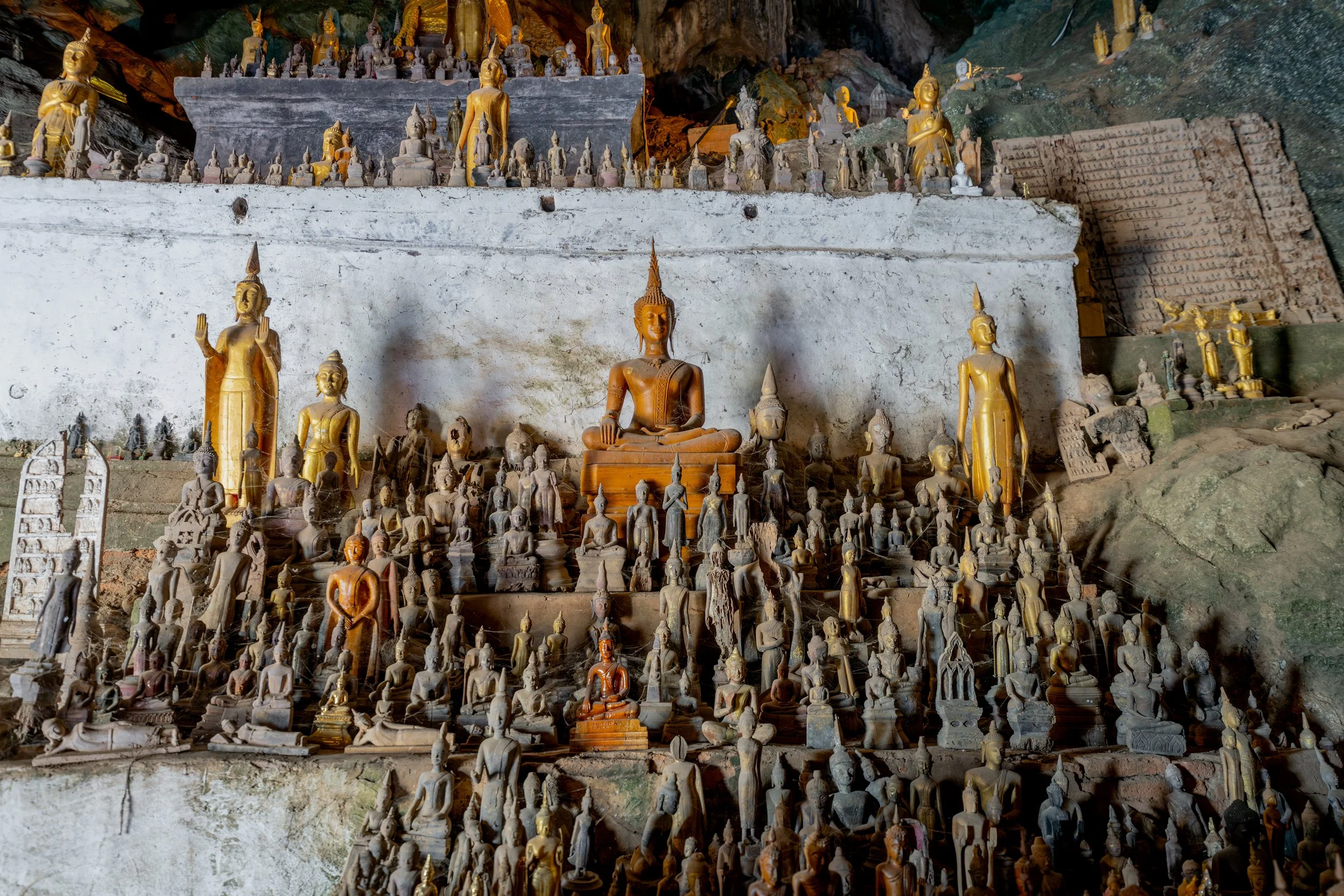 In den Höhlen stapeln sich Buddhafiguren unterschiedlichster Größe und Materialien, die von Pilgern als Opfergaben und Schutzgaben hinterlassen wurden.