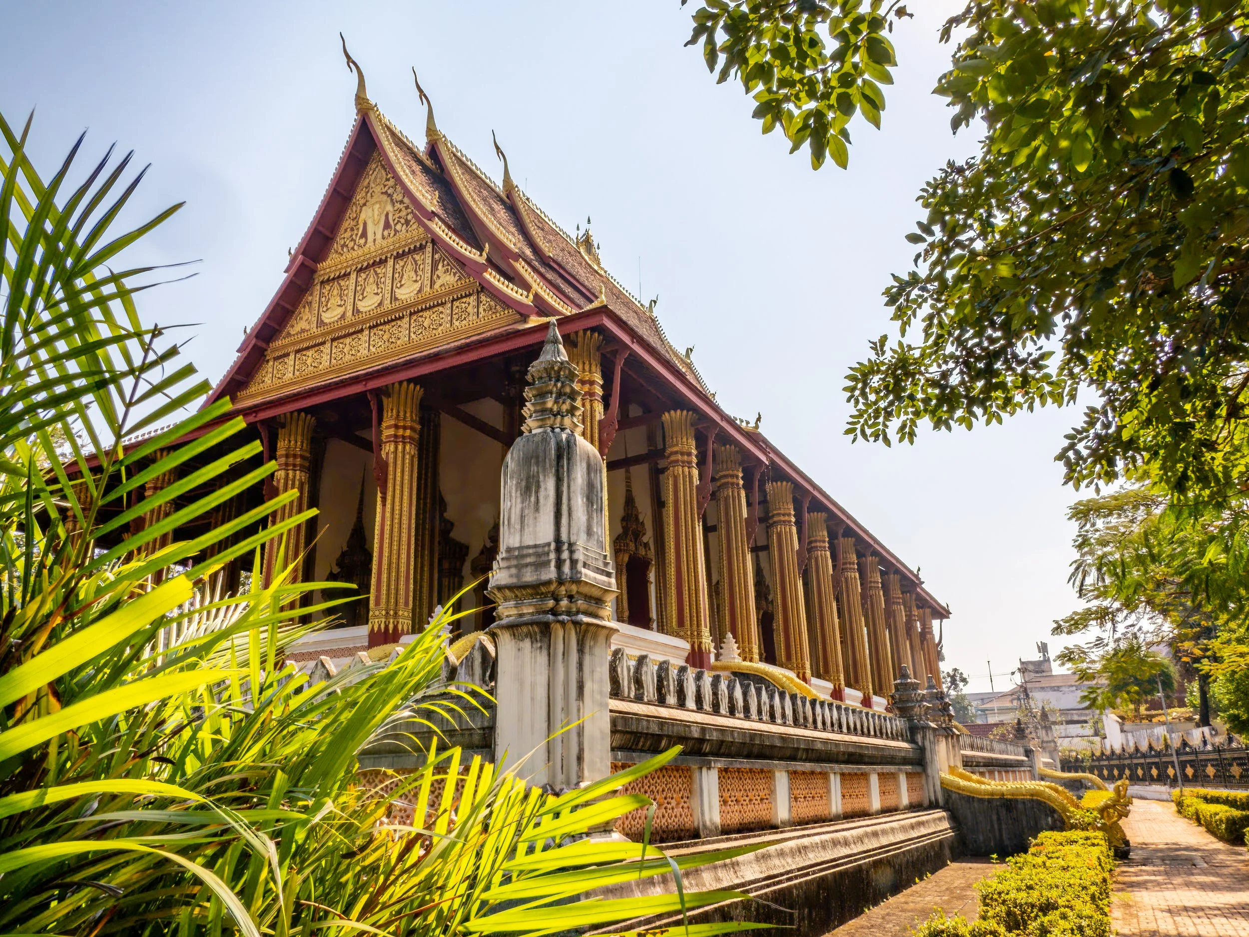 Die ruhige Anlage mit ihren kunstvoll verzierten Säulen und gepflegten Gärten spiegelt den klassischen Stil laotischer Tempelarchitektur wider.