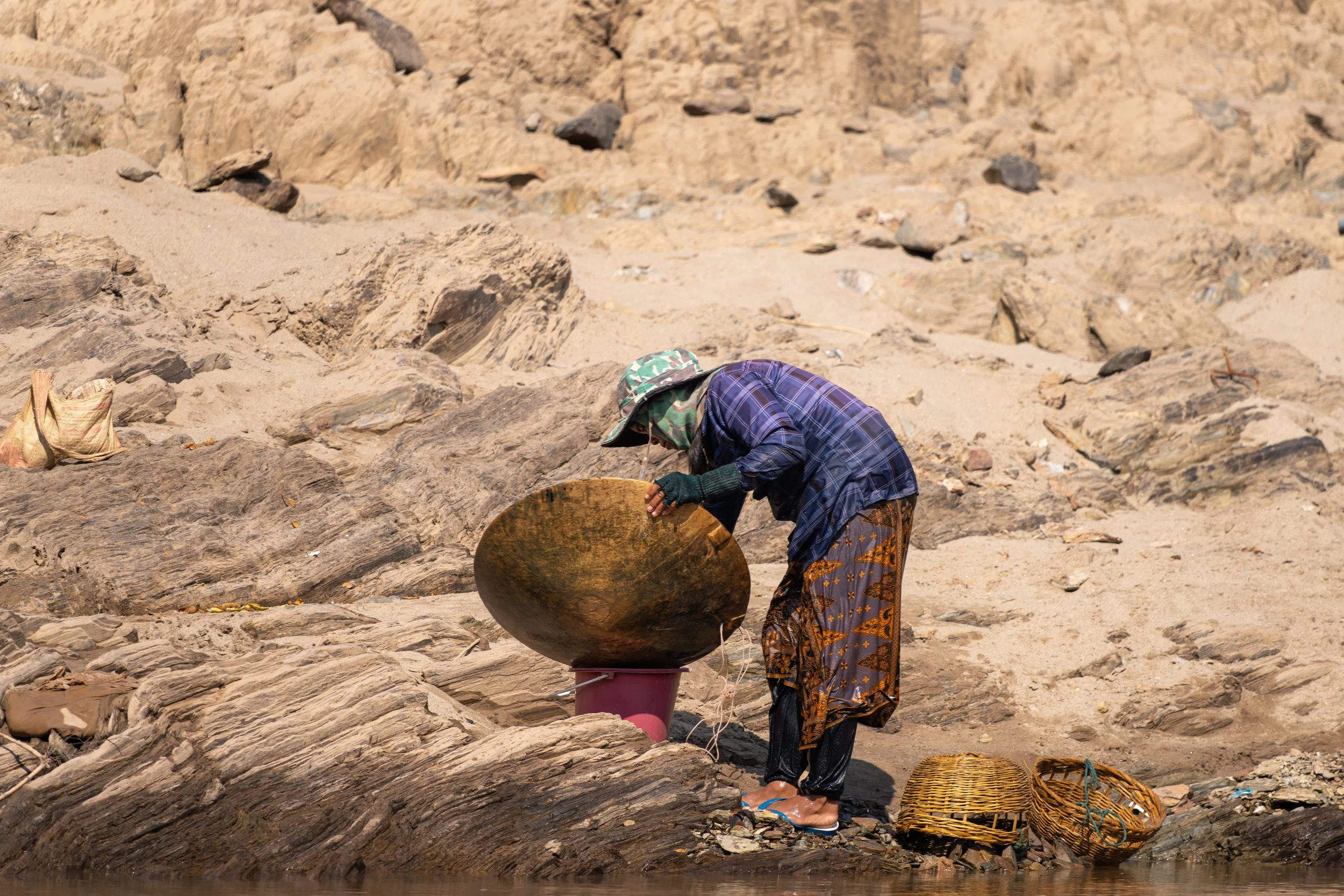Goldwäscher am Mekong suchen mit einfachen Sieben und Schalen nach feinen Goldpartikeln im Flusssand. Diese mühsame Arbeit wird seit Generationen praktiziert und ist für einige Familien bis heute eine zusätzliche Einnahmequelle.