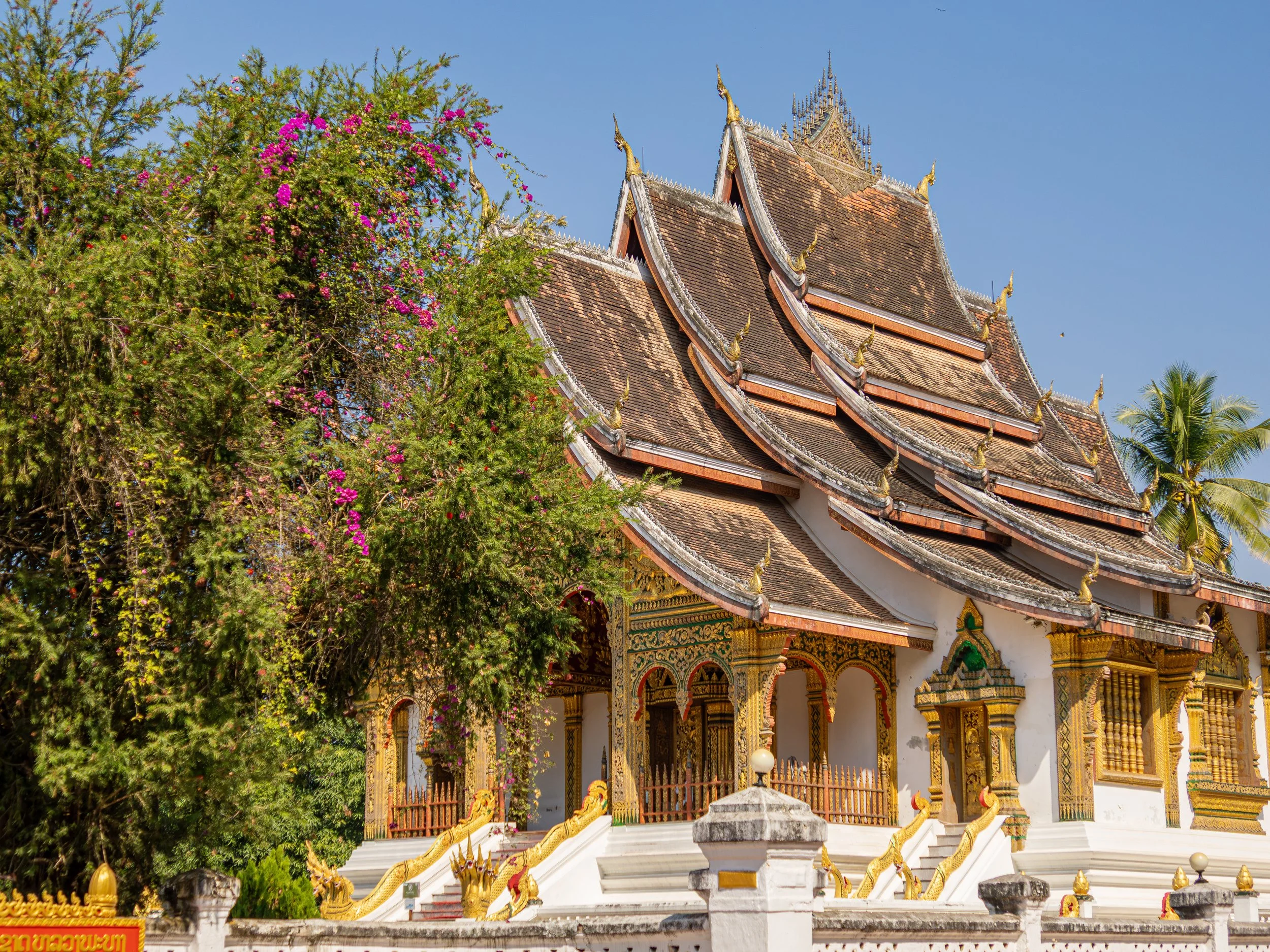 Der reich verzierte Bau verbindet traditionelle laotische Architektur mit königlicher Symbolik und unterstreicht die religiöse und historische Bedeutung des ehemaligen Herrschaftszentrums.