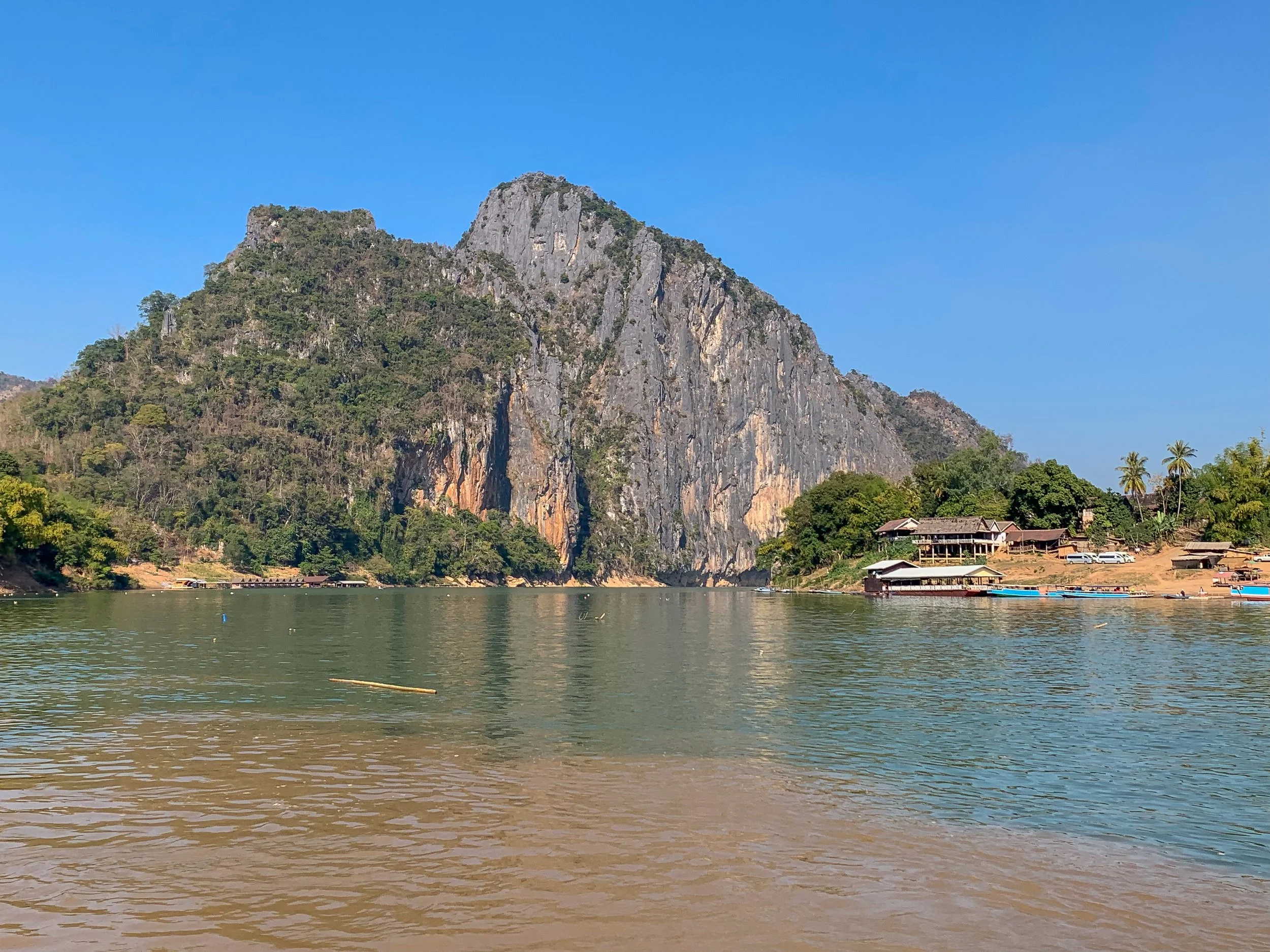 An den Pak-Ou-Höhlen trifft das bräunliche Wasser des Mekong sichtbar auf das bläulich klare Wasser des Nam Ou. Der Zusammenfluss zweier Flüsse schafft hier ein eindrucksvolles Naturschauspiel direkt unterhalb der heiligen Höhlen.