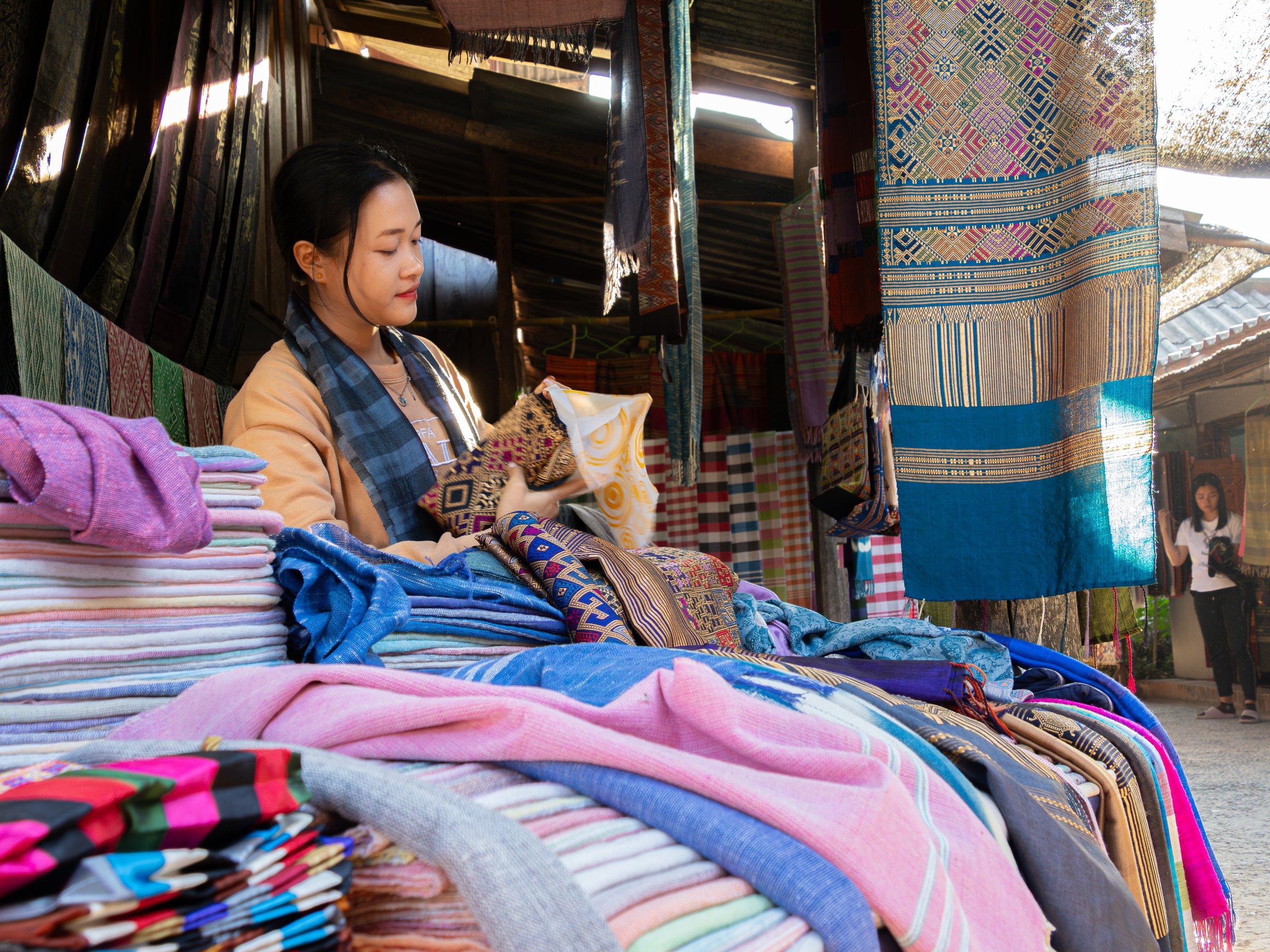 Die handgewebten Schals werden auf lokalen Märkten angeboten und sind Ausdruck traditioneller Muster, Farben und Handwerkskunst der Region.