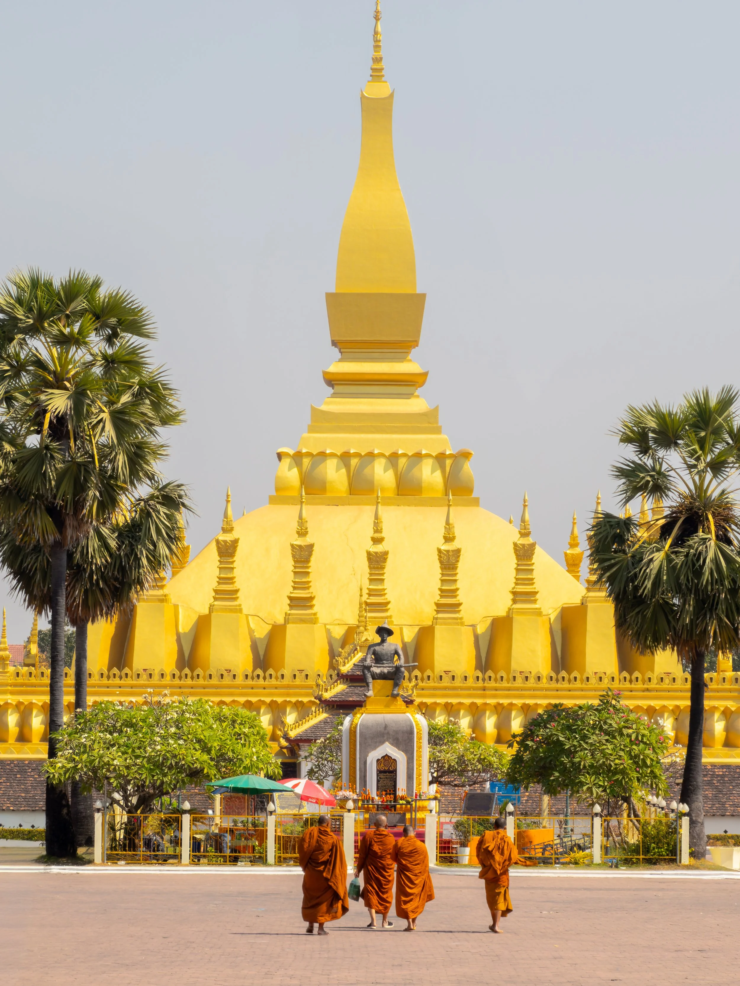 Die Präsenz der Mönche vor dem Monument unterstreicht die enge Verbindung von königlicher Geschichte und buddhistischer Tradition in Laos.