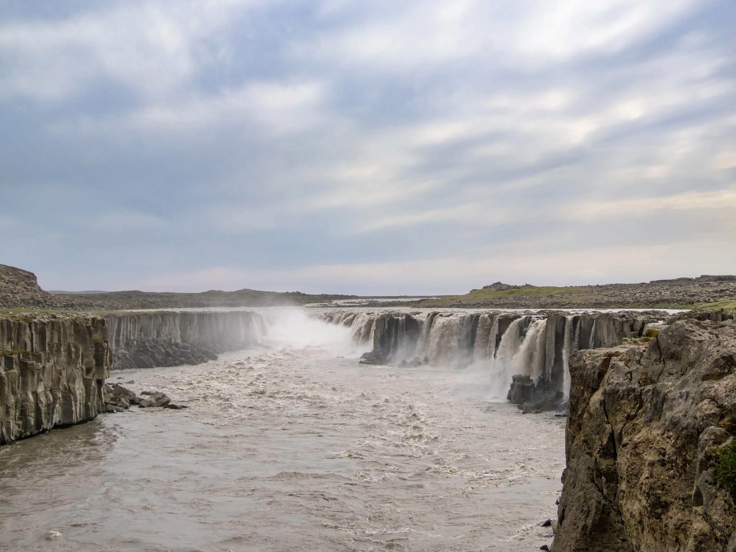 Der Selfoss liegt flussaufwärts am selben Gletscherfluss und zeichnet sich durch seine breite, hufeisenförmige Kaskade aus, die im Gegensatz zur Wucht des Dettifoss eine ruhigere, fast harmonische Wirkung entfaltet.