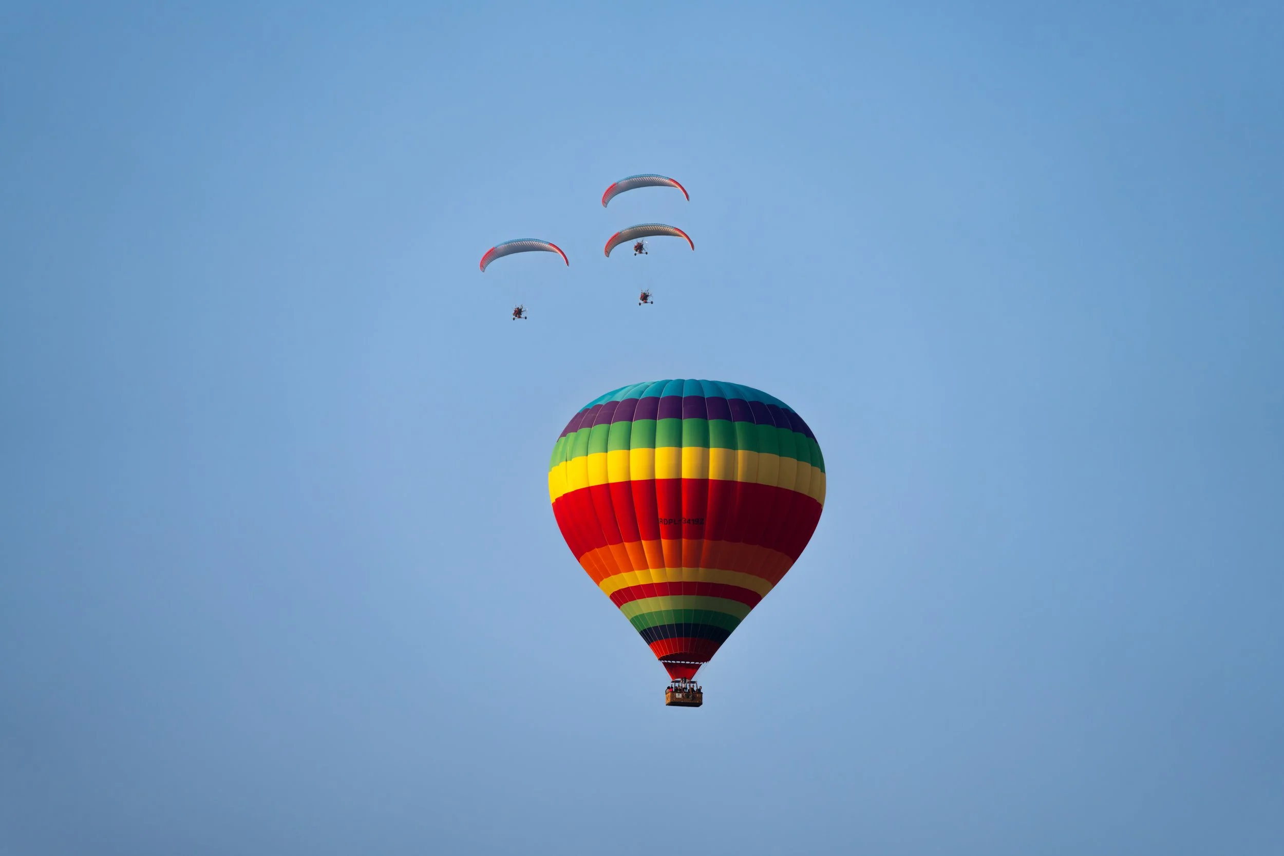 Heißluftballons und Motorgleitschirme bieten in Vang Vieng eine besondere Perspektive auf die Karstlandschaft und zeigen die beeindruckende Weite der Region aus der Luft. Besonders in den frühen Morgen- oder Abendstunden prägen sie das Panorama über 