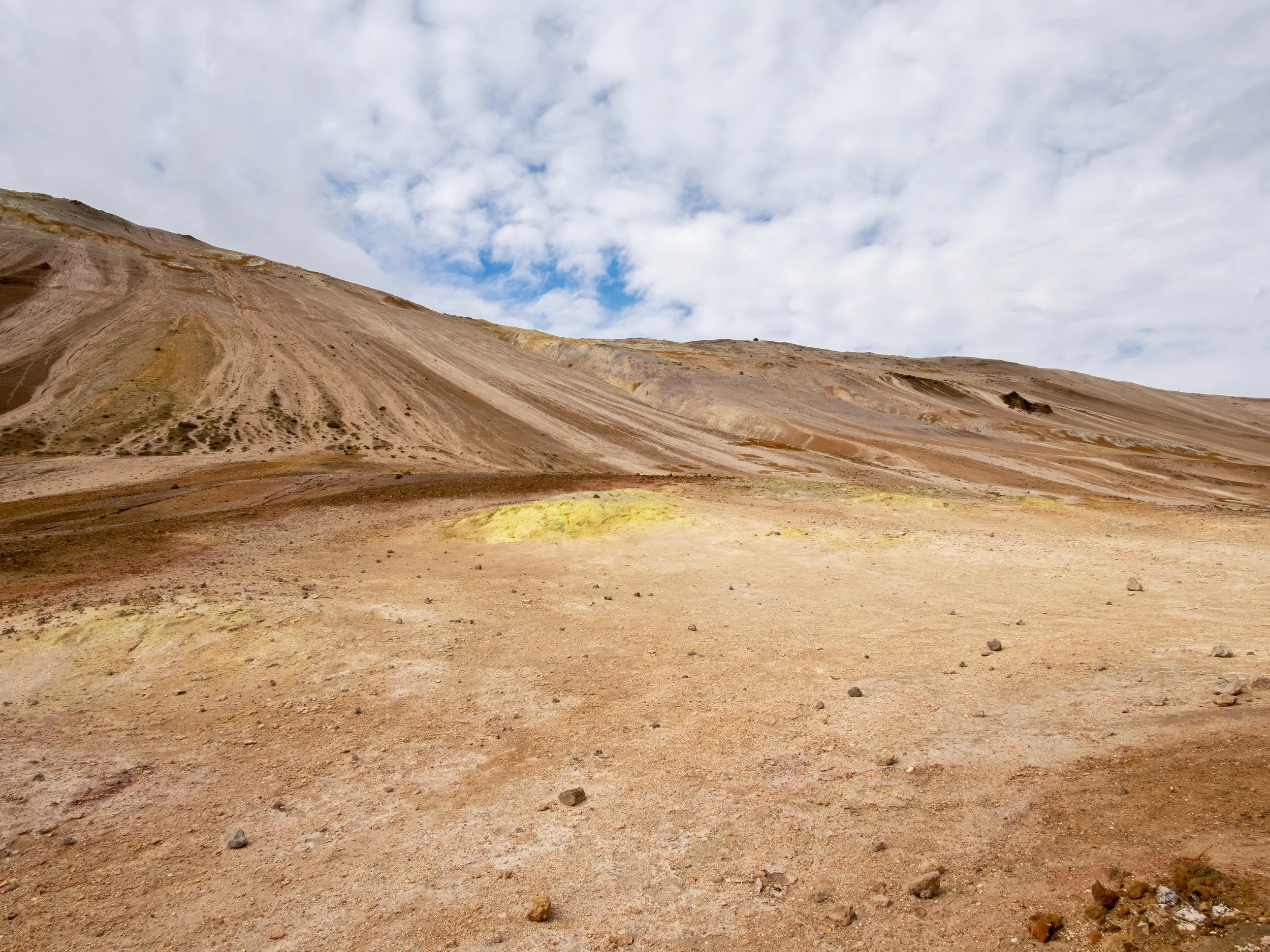 Die karge, farbintensive Umgebung mit gelben, roten und grauen Erdflächen entsteht durch austretende Gase und mineralreiche Ablagerungen.