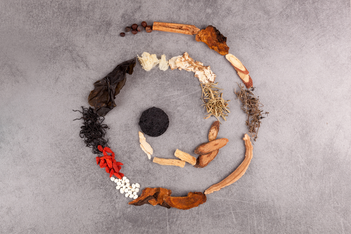 Verschiedene Heilpflanzen und Naturstoffe im Kreis angeordnet, als Symbol für Naturheilkunde im Ayurveda.