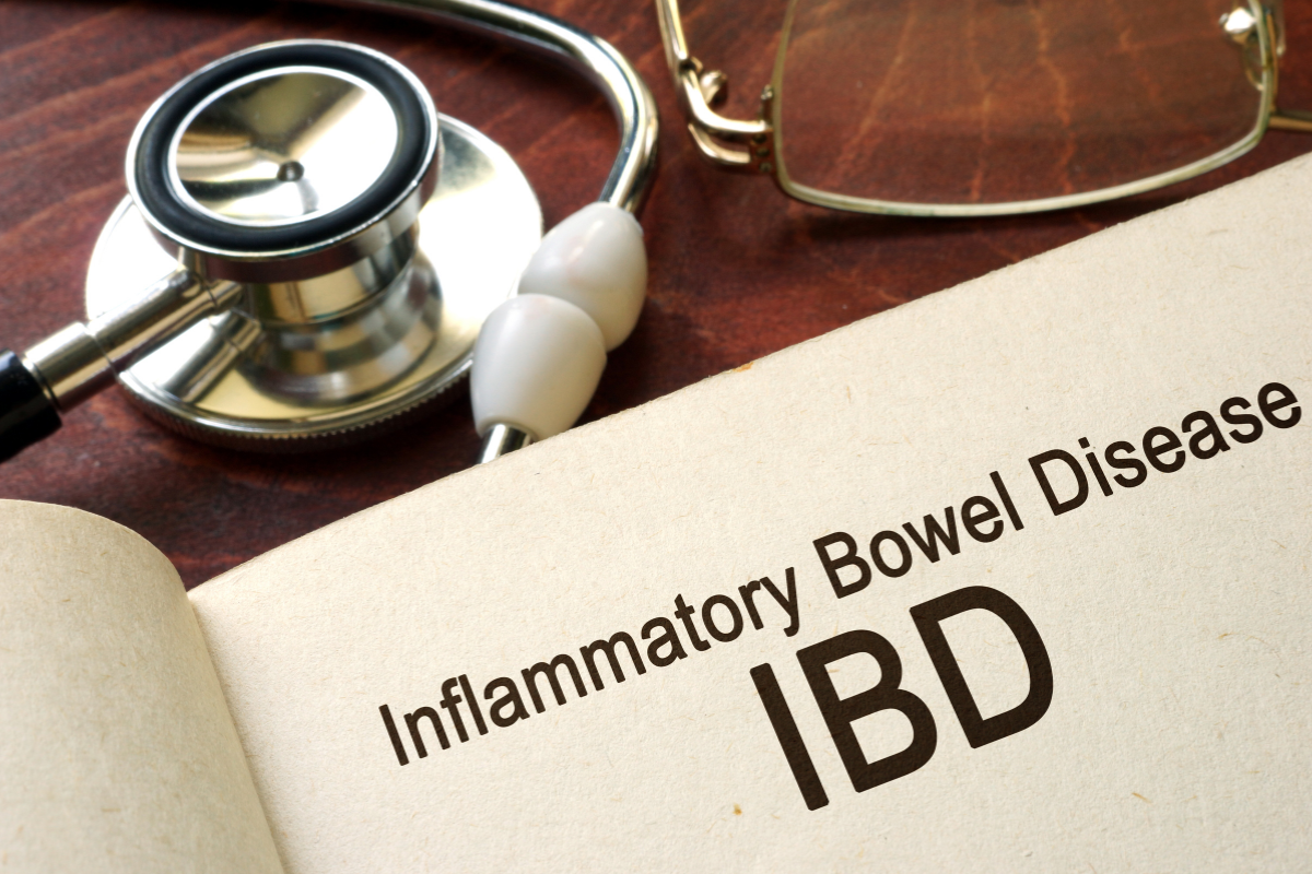 Aufgeschlagenes Buch mit dem Begriff Inflammatory Bowel Disease (IBD) neben einem Stethoskop, chronische Darmentzündung beim Hund