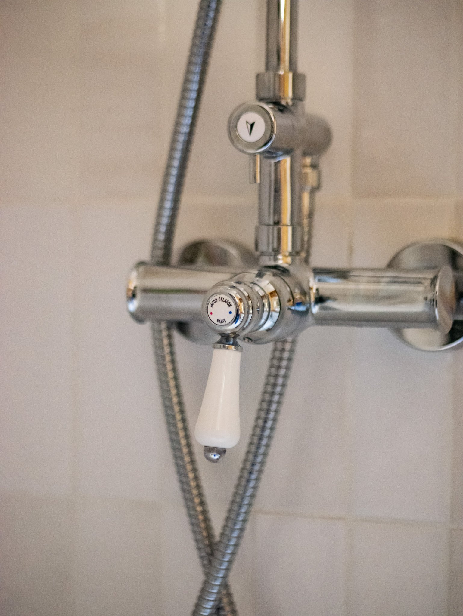 Rénovation d'un salle de bain dans un appartement ancien à Rouen. Meubles sur-mesure avec étagères et placards en bois foncé, douche à l'italienne et baignoire avec huisseries noires, peinture couleur cumin, miroir sur mesure avec zellige mural blanc