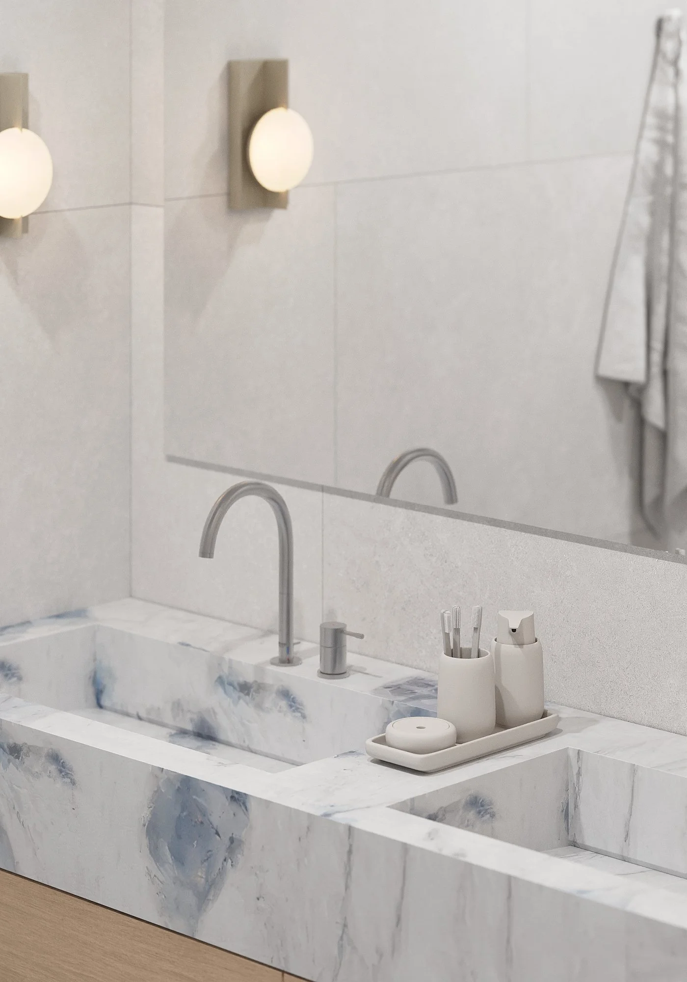 Bathroom sink area with marble countertop, two faucets, and a mirror. Two wall-mounted lights and a tray with toiletries are visible.