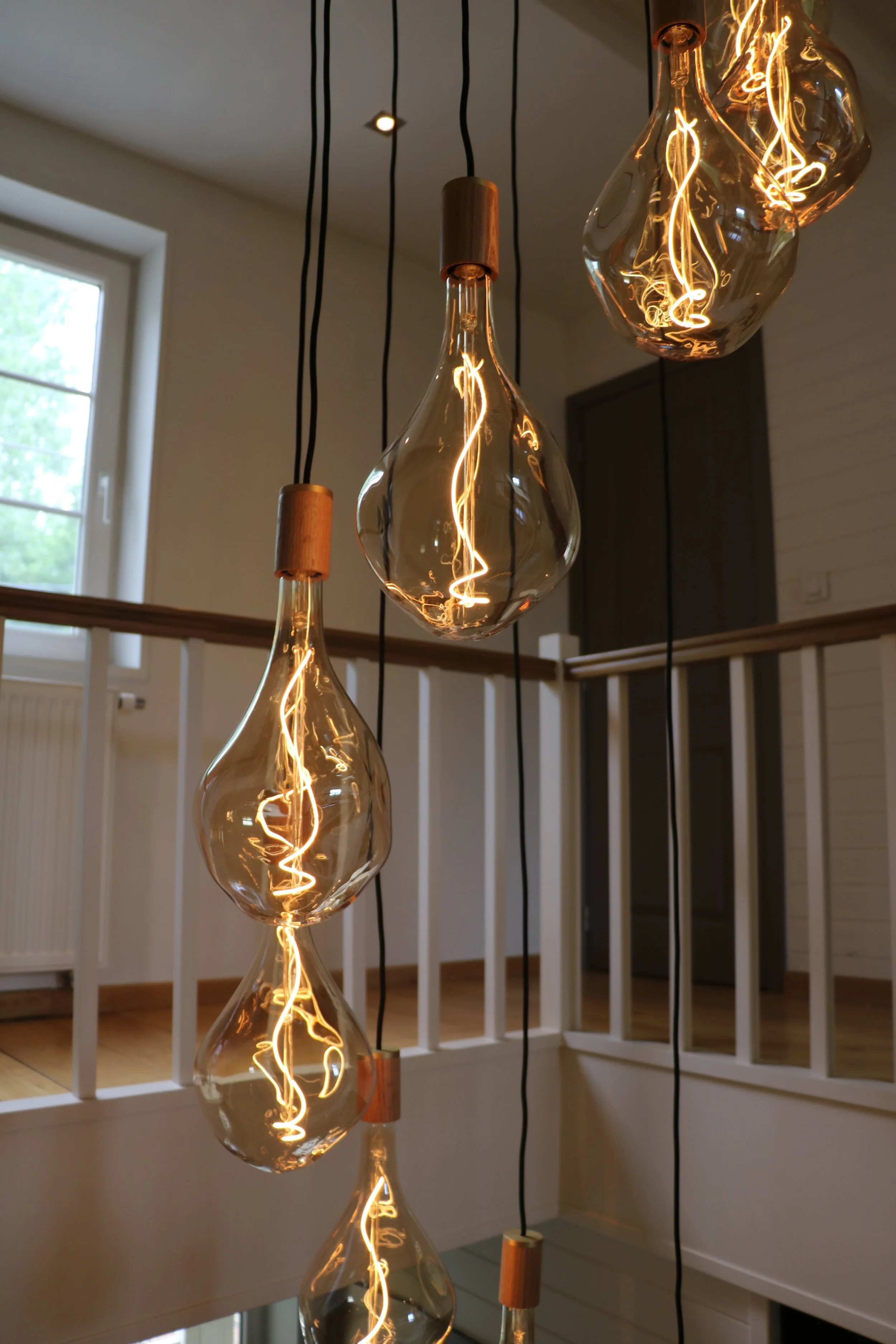 Hangende decoratieve pendellampen met zichtbare filamenten in een moderne interieursetting.