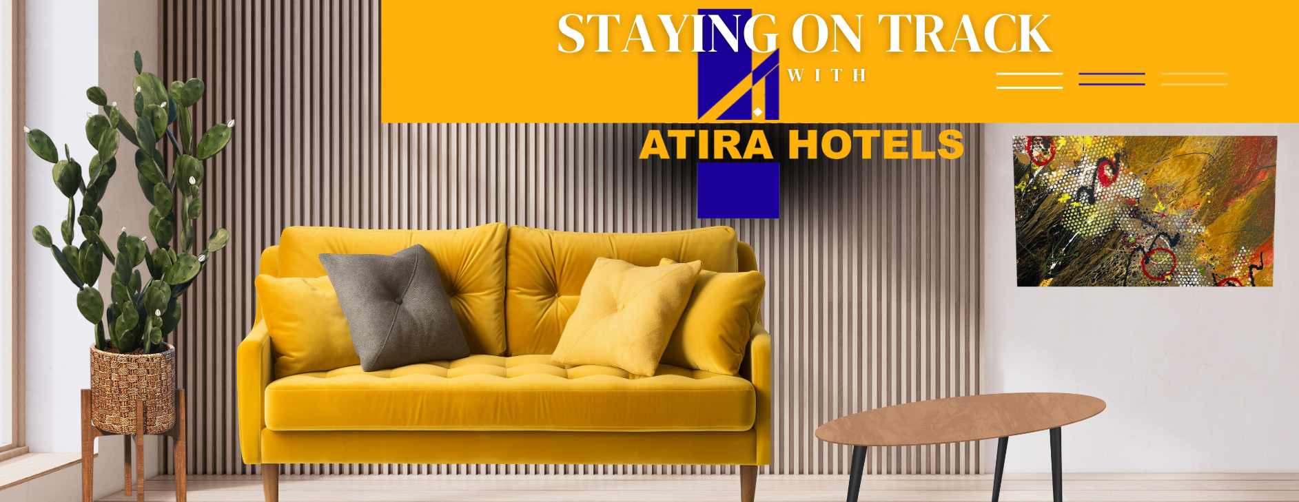 Interior of a hotel lounge with a yellow sofa, gray and yellow throw pillows, a potted plant, a wooden coffee table, and an abstract painting on the wall. There is a decorative vertical wooden slat wall and a sign that reads 'Staying on Track with Atira Hotels' in bold colors.