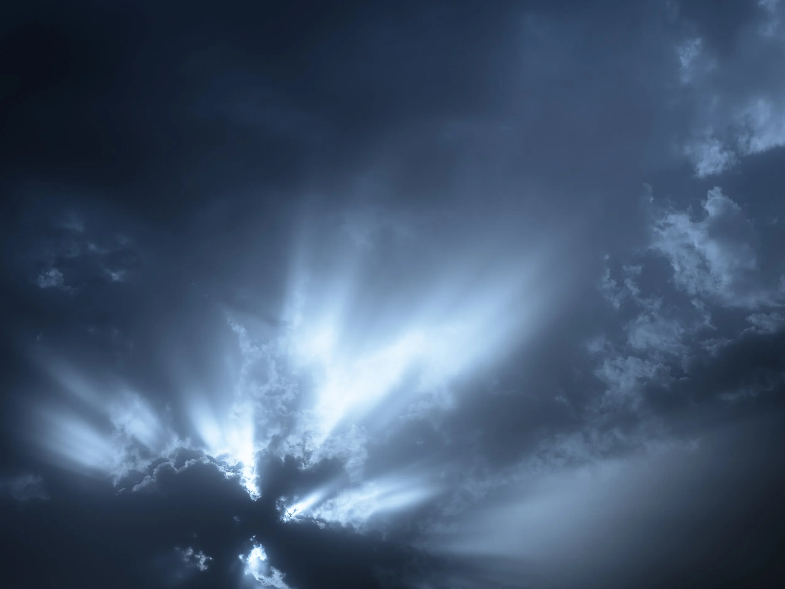 Nuages sombres avec des rayons de lumière perçant à travers.