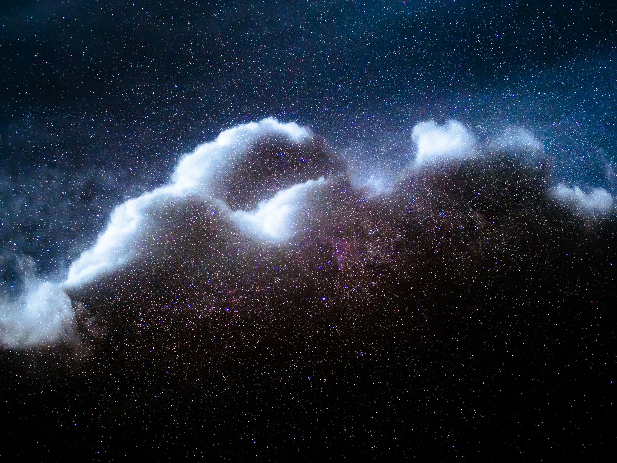 Nuages blancs dans un ciel étoilé avec une galaxie visible au centre