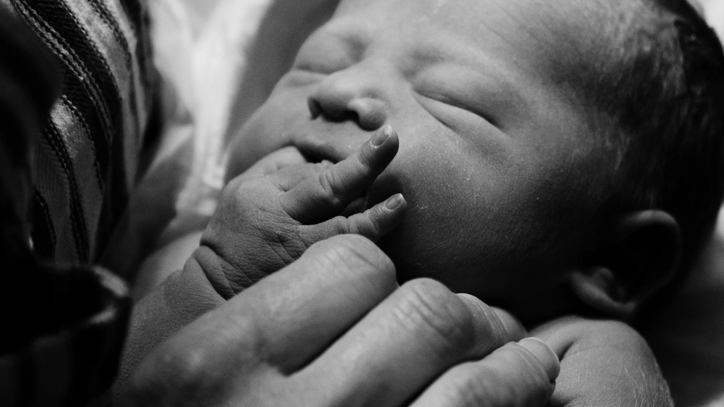 Black and white close-up of a newborn's face, calm birth outcomes with Birthing by Nature