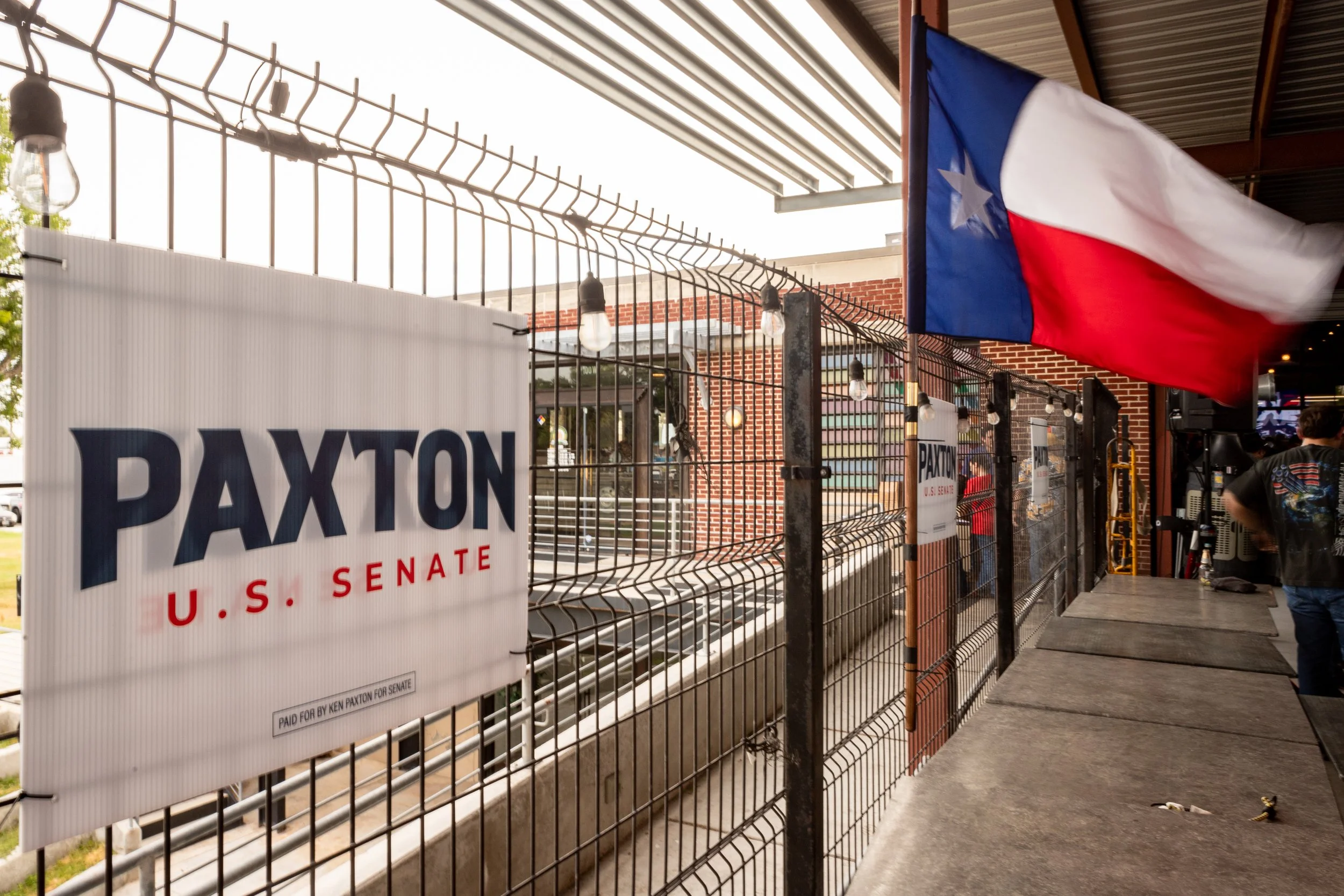 A Paxton for U.S. Senate sign and a Texas flag are displayed before the “Rally in the Valley” event at University Draft House in McAllen, TX,  on July 14, 2026.