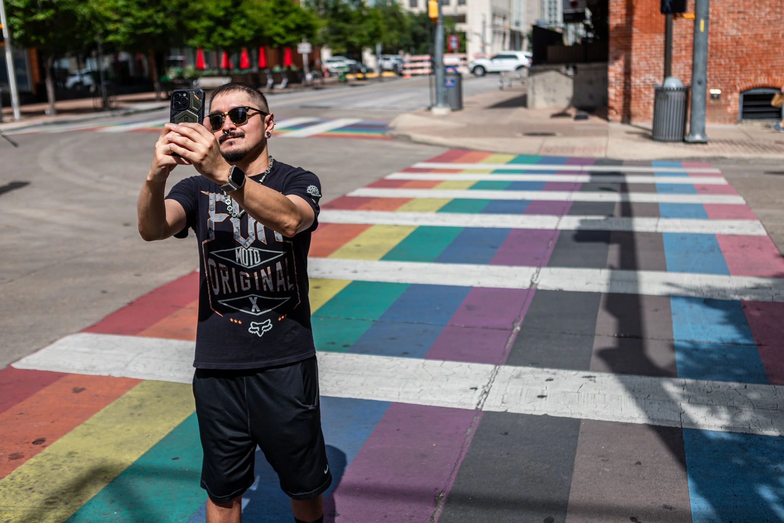 An attendee takes a photo on the rainbow crosswalk on 4th Street on June 20, 2026, in downtown Austin, TX.