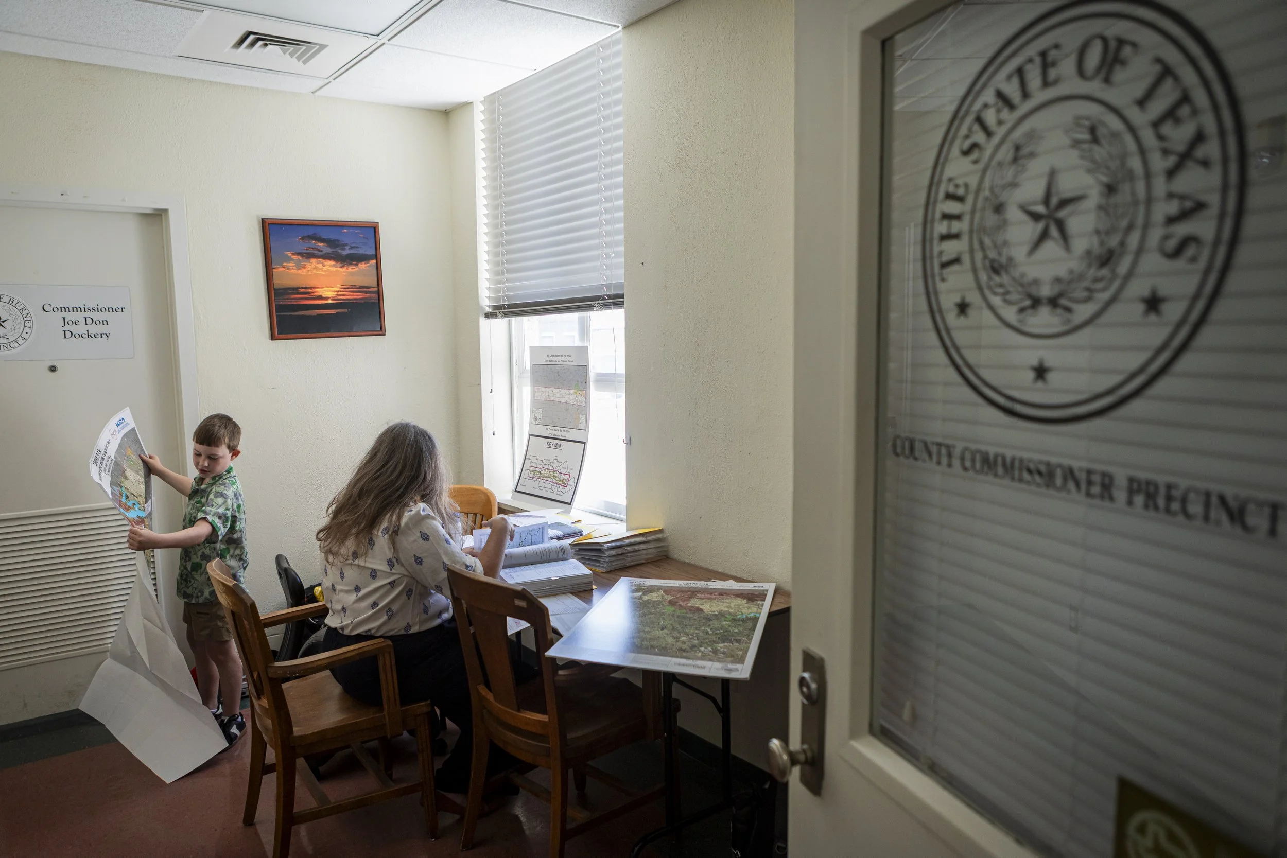 Mia Sarot organizes all the documents and maps of the printed copy application from Oncore and LCRA inside the County Commissioner Precinct in Burnet, TX on Aug. 11, 2026. 