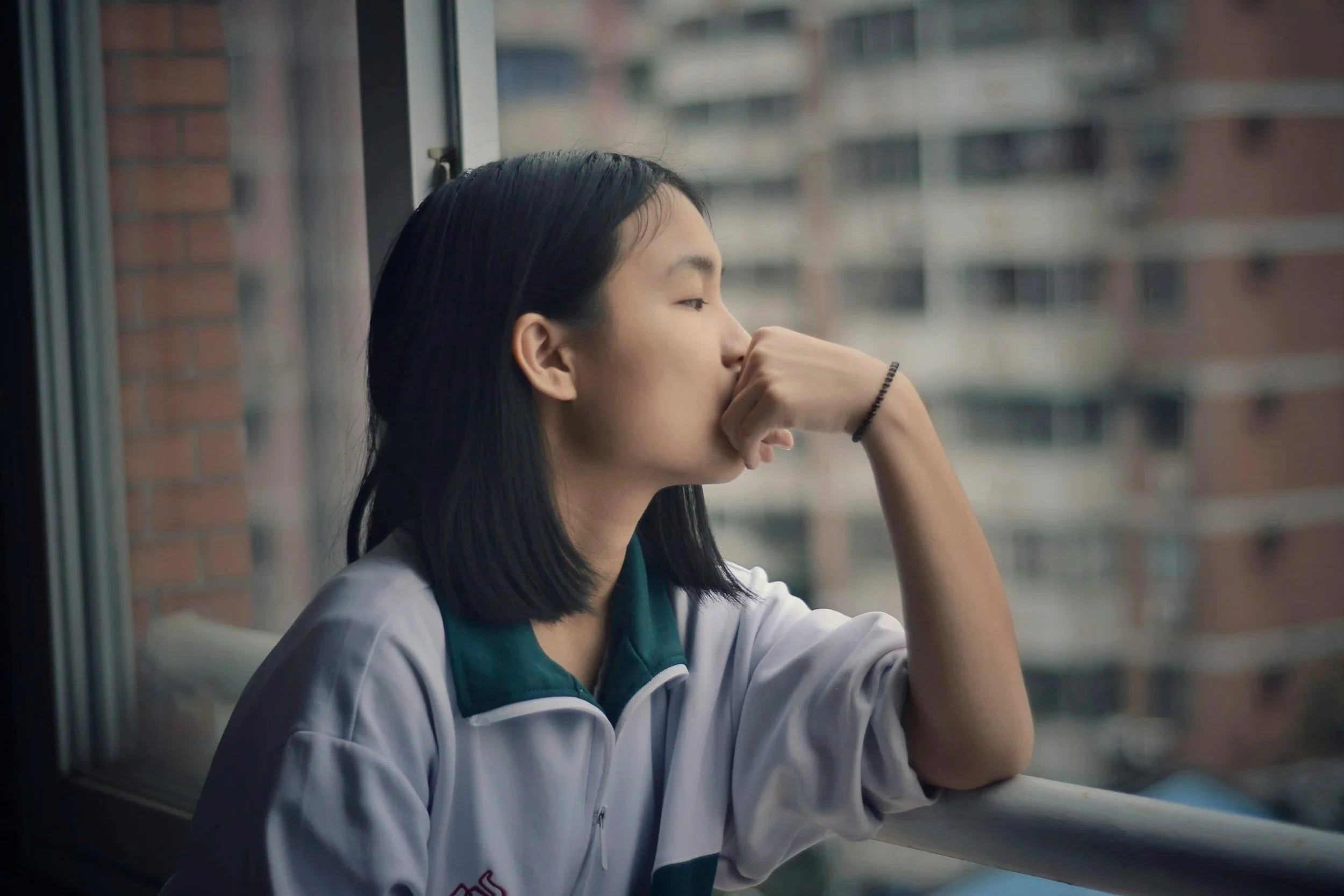 Person sitting alone looking stressed and thoughtful about financial challenges and money stress.