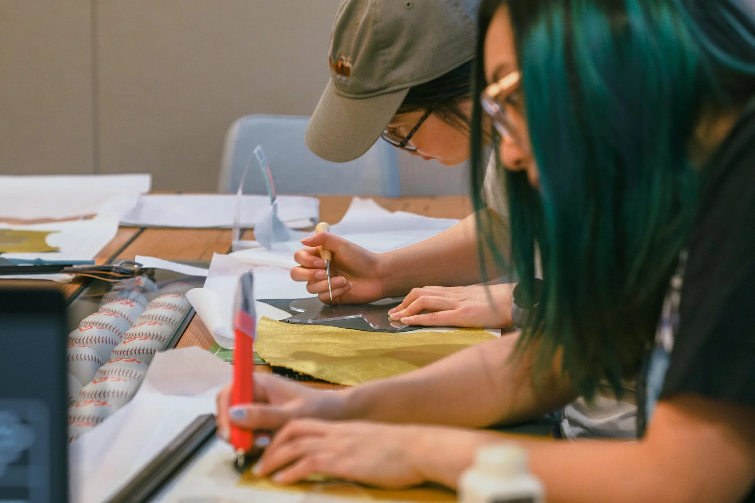 Two people crafting leather projects.