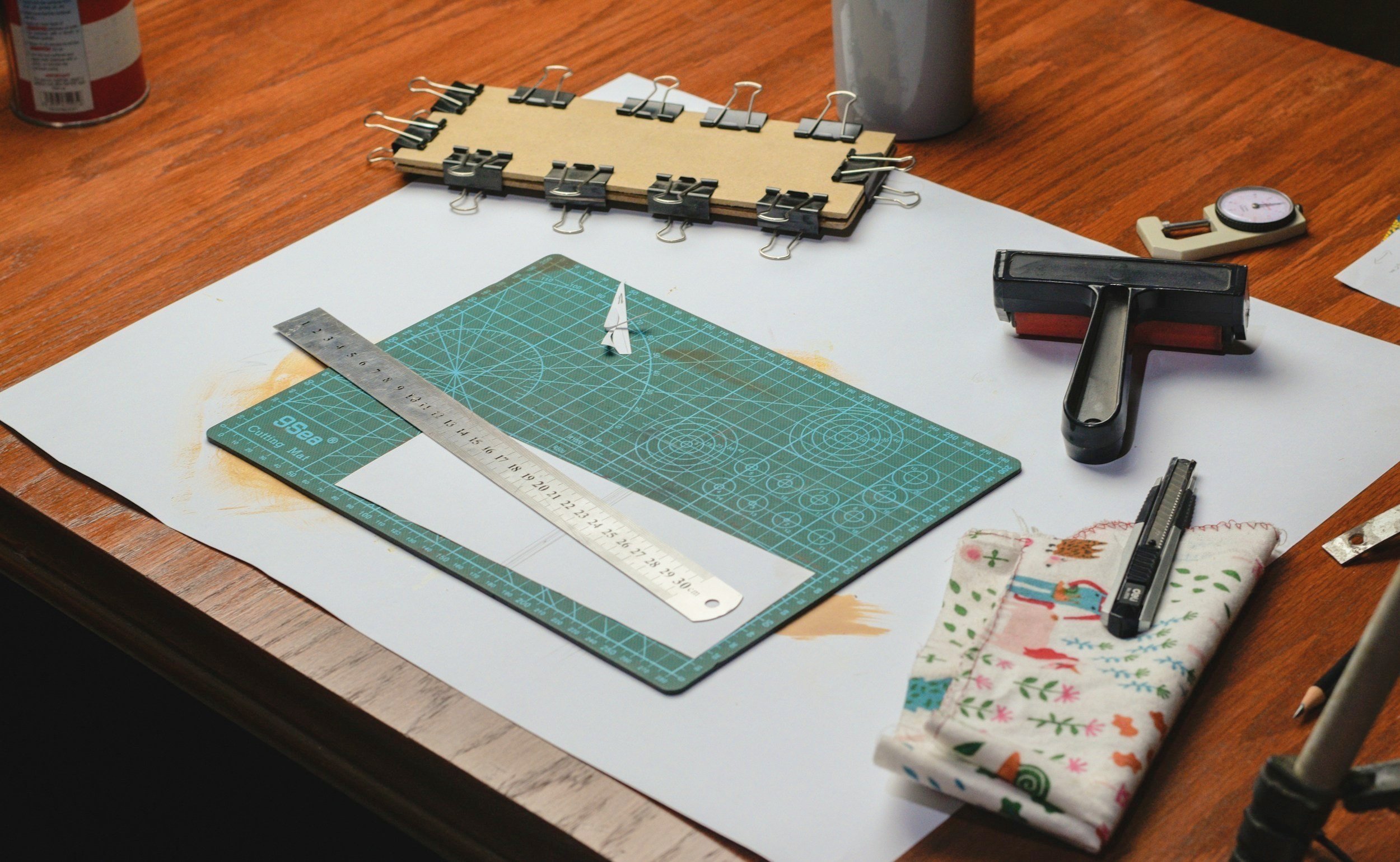 Leathercrafting workspace with cutting mats, brass hardware, and specialized hand tools